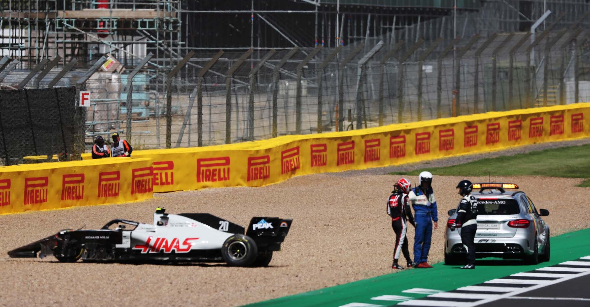 SILVERSTONE, UNITED KINGDOM - AUGUST 02: Kevin Magnussen, Haas F1, is led away from his crashed car after contact with Alexander Albon, Red Bull Racing during the British GP at Silverstone on Sunday August 02, 2020 in Northamptonshire, United Kingdom. (Photo by Charles Coates / LAT Images)