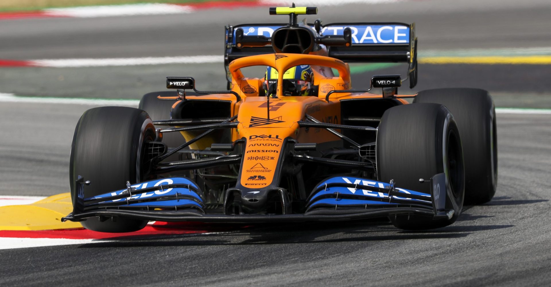 Lando Norris, McLaren MCL35, bounces over a kerb in a chicane