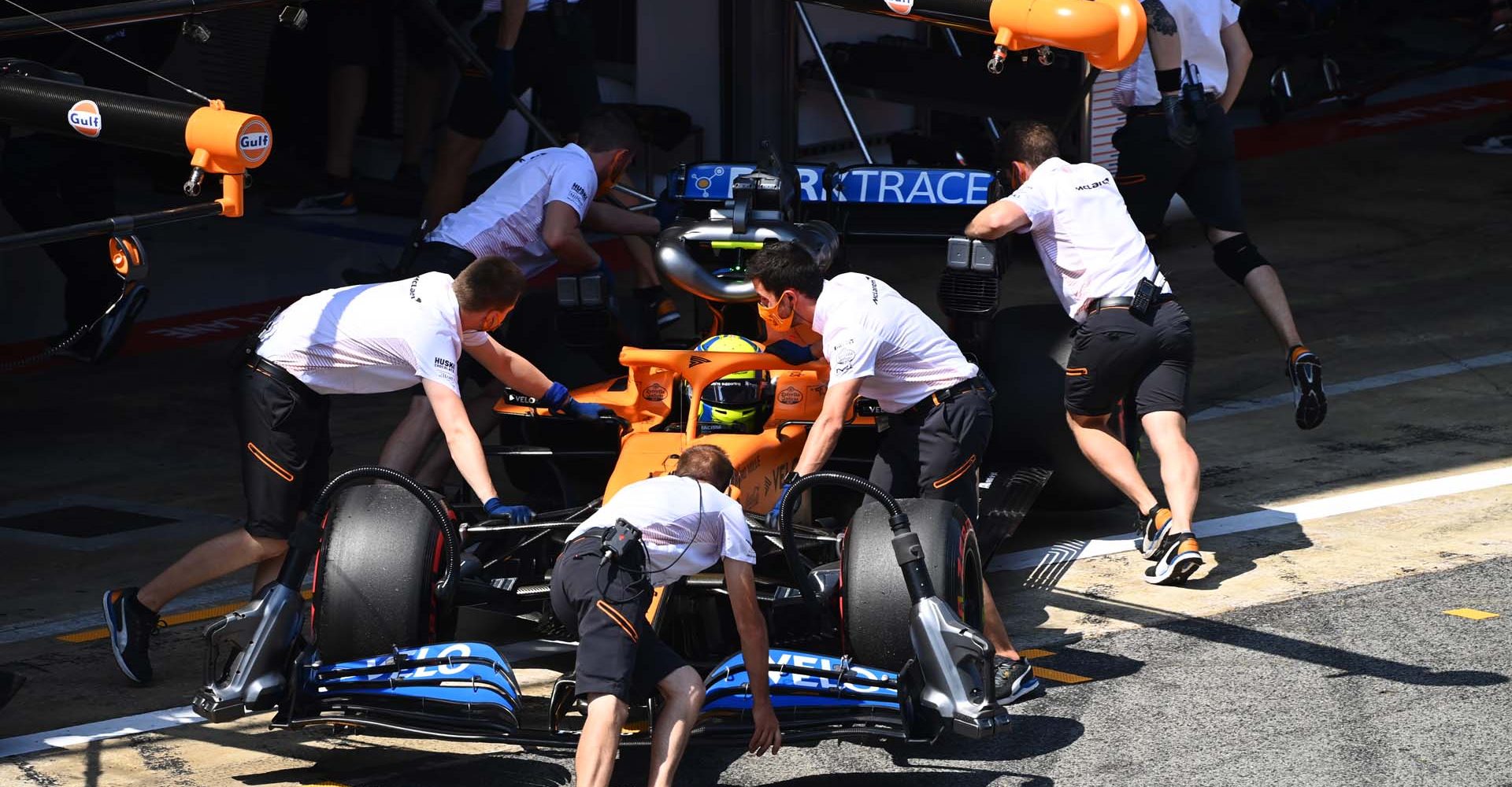 Lando Norris, McLaren MCL35, is returned to the garage. Mechanics wheel the car backwards