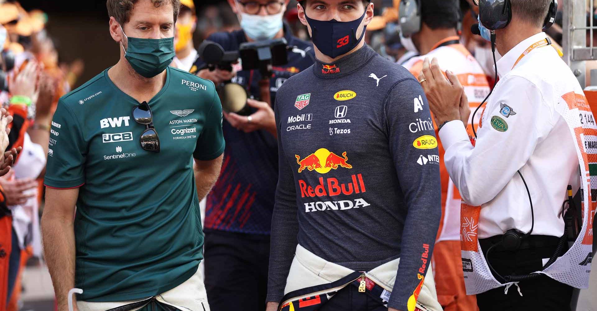 ABU DHABI, UNITED ARAB EMIRATES - DECEMBER 12: Sebastian Vettel of Germany and Aston Martin F1 Team and Max Verstappen of Netherlands and Red Bull Racing walk out for the F1 drivers parade ahead of the F1 Grand Prix of Abu Dhabi at Yas Marina Circuit on December 12, 2021 in Abu Dhabi, United Arab Emirates. (Photo by Lars Baron/Getty Images)