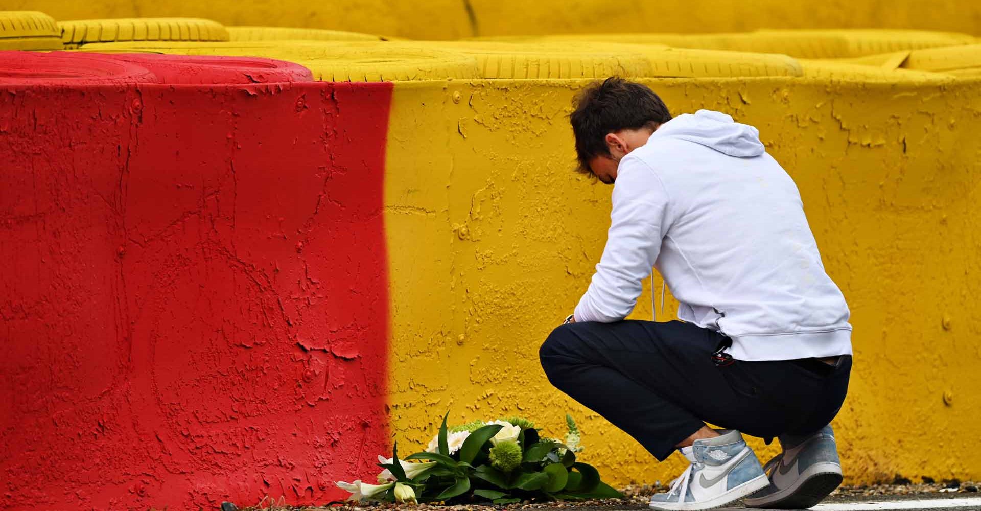 SPA, BELGIUM - AUGUST 26: Pierre Gasly of France and Scuderia AlphaTauri leaves flowers at the site of the crash of the late F2 driver Anthoine Hubert during previews ahead of the F1 Grand Prix of Belgium at Circuit de Spa-Francorchamps on August 26, 2021 in Spa, Belgium. (Photo by Dan Mullan/Getty Images)