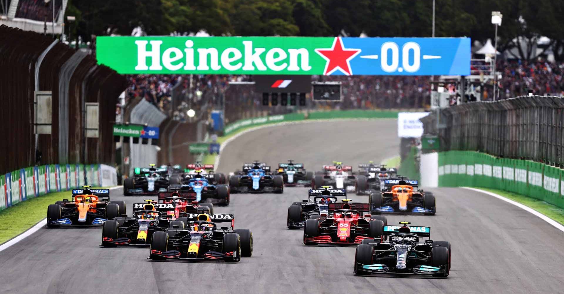 SAO PAULO, BRAZIL - NOVEMBER 13: Valtteri Bottas of Finland driving the (77) Mercedes AMG Petronas F1 Team Mercedes W12 leads Max Verstappen of the Netherlands driving the (33) Red Bull Racing RB16B Honda and the rest of the field into turn one at the start during the sprint ahead of the F1 Grand Prix of Brazil at Autodromo Jose Carlos Pace on November 13, 2021 in Sao Paulo, Brazil. (Photo by Lars Baron/Getty Images)