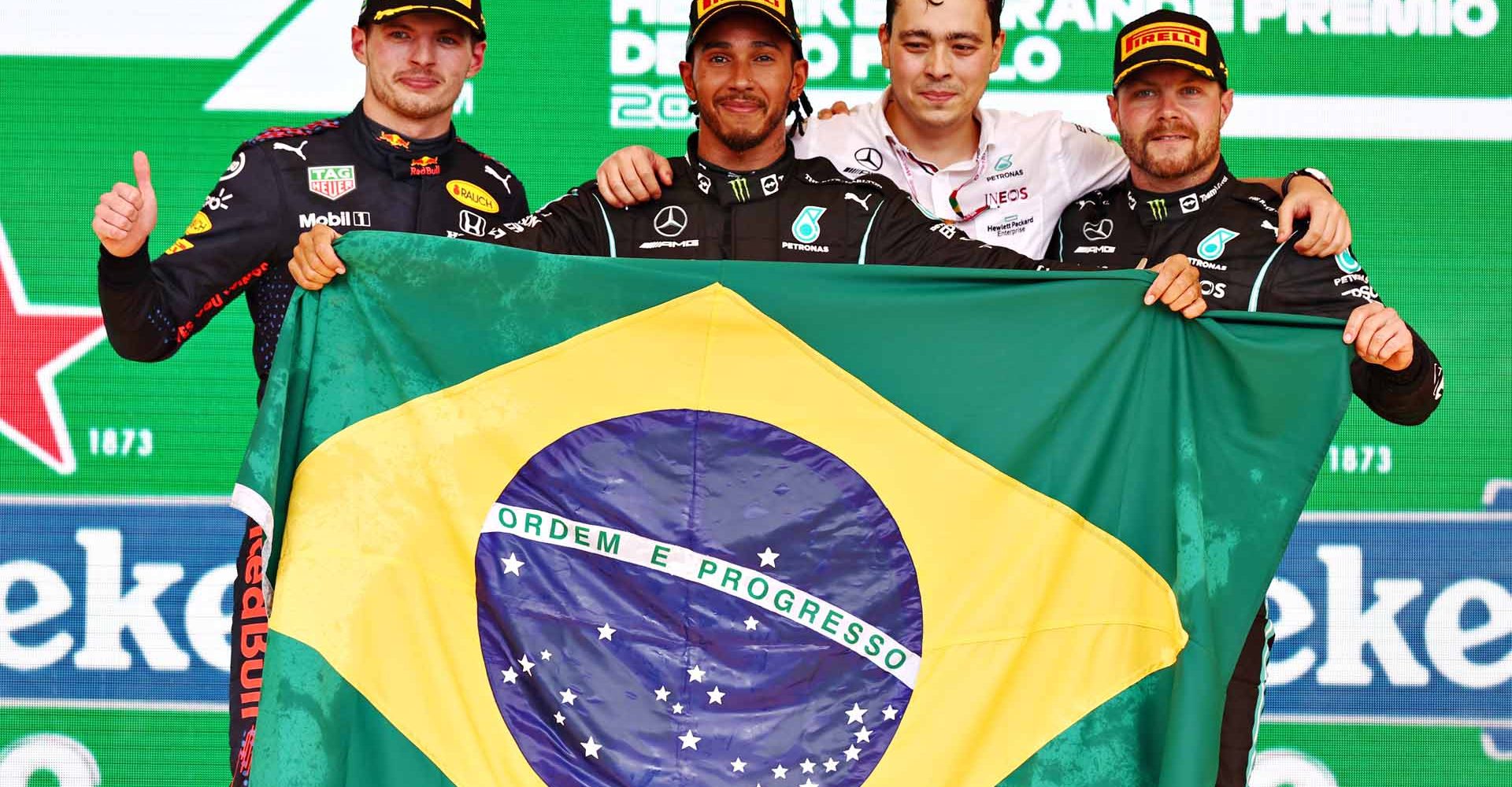 SAO PAULO, BRAZIL - NOVEMBER 14: Race winner Lewis Hamilton of Great Britain and Mercedes GP, second placed Max Verstappen of Netherlands and Red Bull Racing and third placed Valtteri Bottas of Finland and Mercedes GP celebrate on the podium during the F1 Grand Prix of Brazil at Autodromo Jose Carlos Pace on November 14, 2021 in Sao Paulo, Brazil. (Photo by Mark Thompson/Getty Images)