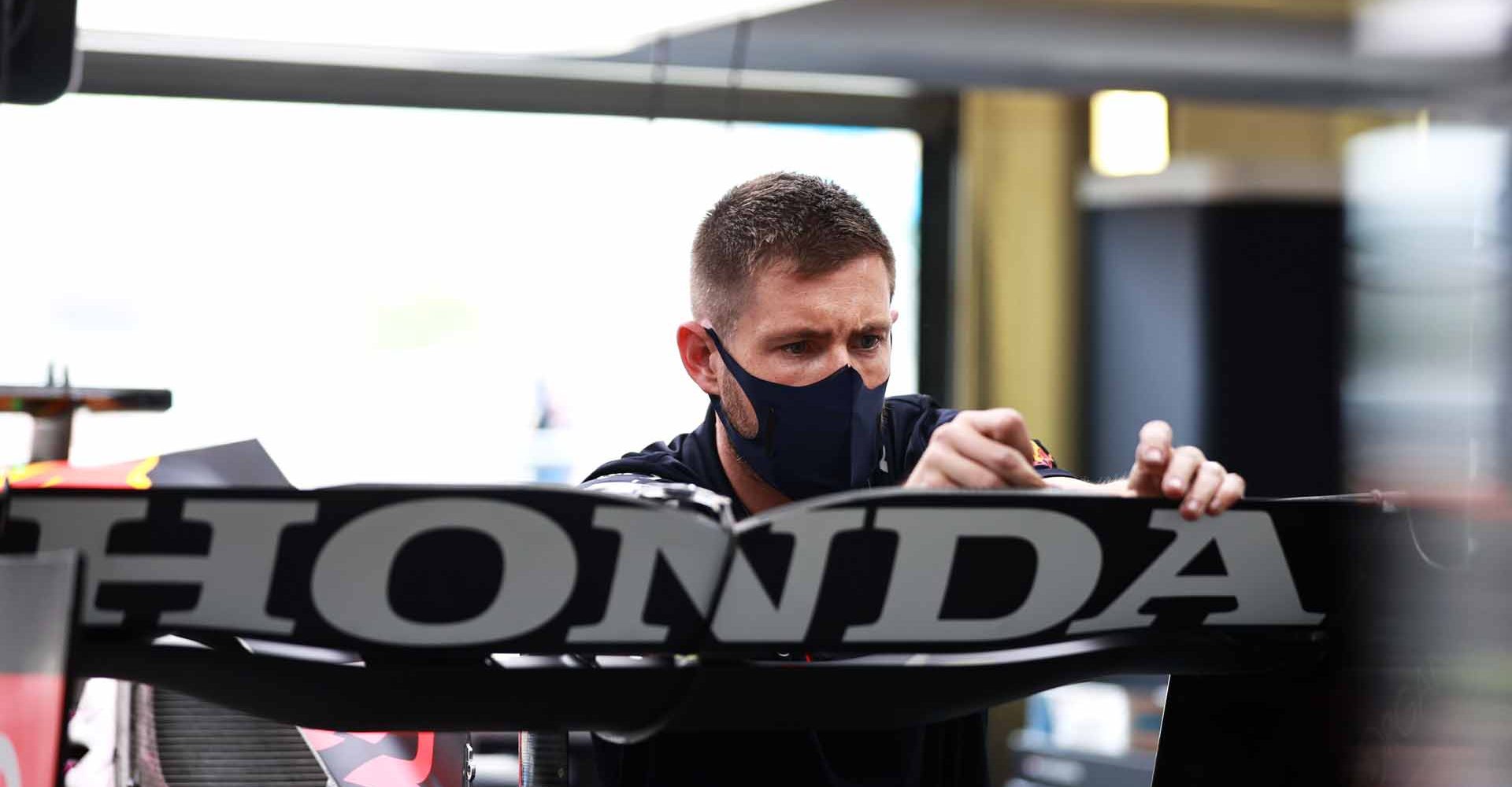 NORTHAMPTON, ENGLAND - JULY 15: Honda Logo, A Red Bull Racing team member works in the garage during previews ahead of the F1 Grand Prix of Great Britain at Silverstone on July 15, 2021 in Northampton, England. (Photo by Mark Thompson/Getty Images)