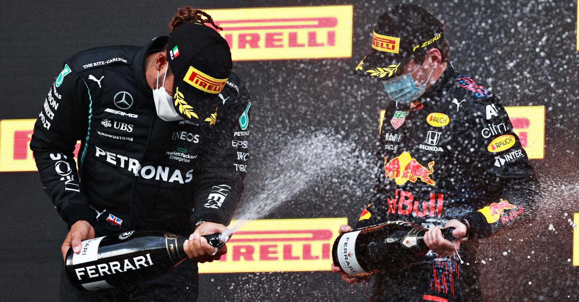 IMOLA, ITALY - APRIL 18: Race winner Max Verstappen of Netherlands and Red Bull Racing and second placed cLewis Hamilton of Great Britain and Mercedes GP celebrate with sparkling wine on the podium during the F1 Grand Prix of Emilia Romagna at Autodromo Enzo e Dino Ferrari on April 18, 2021 in Imola, Italy. (Photo by Mark Thompson/Getty Images)