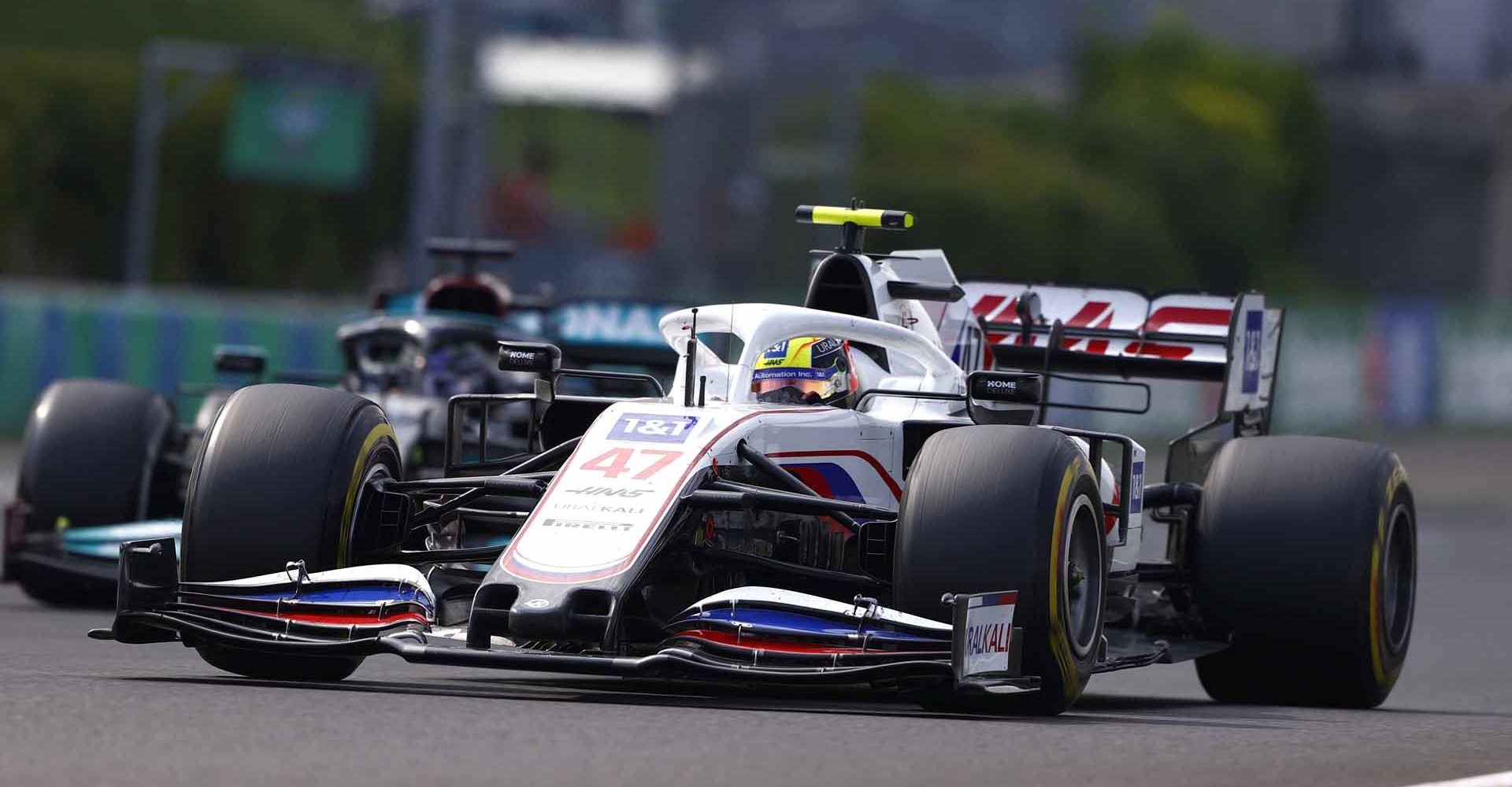 HUNGARORING, HUNGARY - AUGUST 01: Mick Schumacher, Haas VF-21 , leads Sir Lewis Hamilton, Mercedes W12 during the Hungarian GP at Hungaroring on Sunday August 01, 2021 in Budapest, Hungary. (Photo by Andy Hone / LAT Images)