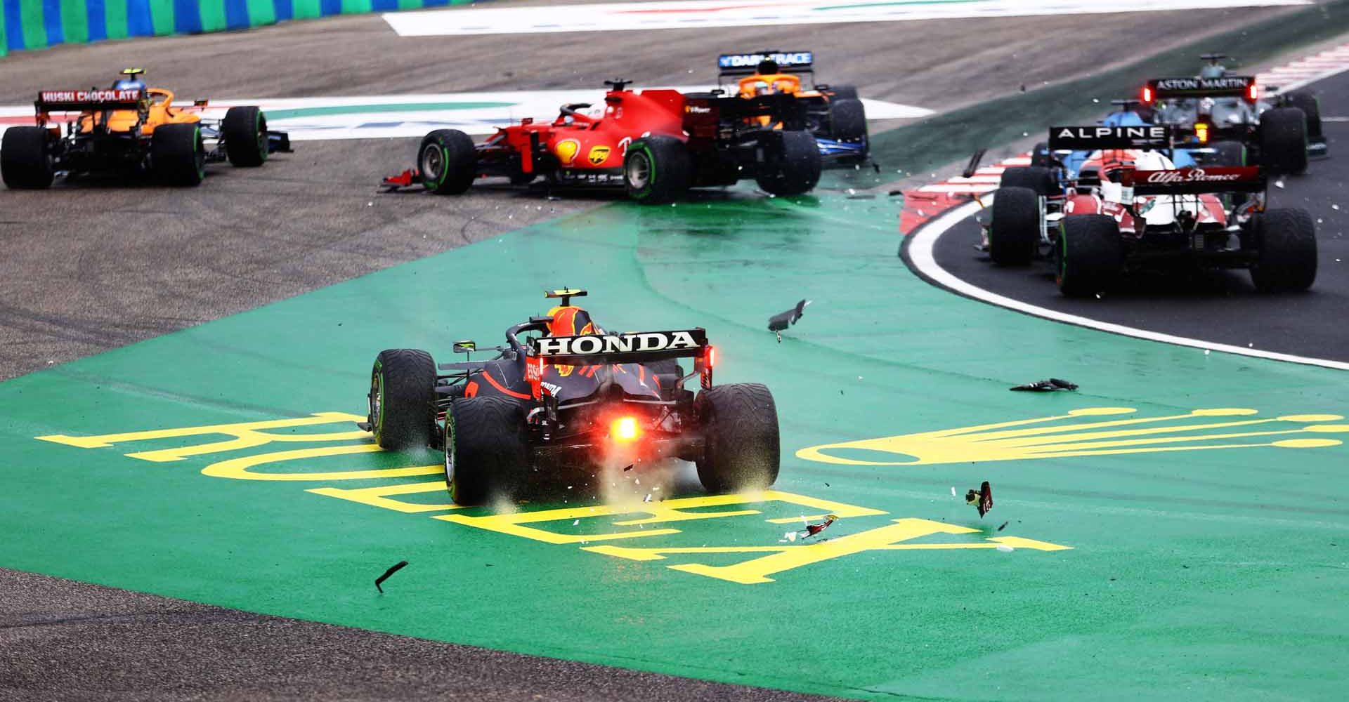 BUDAPEST, HUNGARY - AUGUST 01: Sergio Perez of Mexico driving the (11) Red Bull Racing RB16B Honda runs wide at the start as cars tangle ahead of him during the F1 Grand Prix of Hungary at Hungaroring on August 01, 2021 in Budapest, Hungary. (Photo by Bryn Lennon/Getty Images)