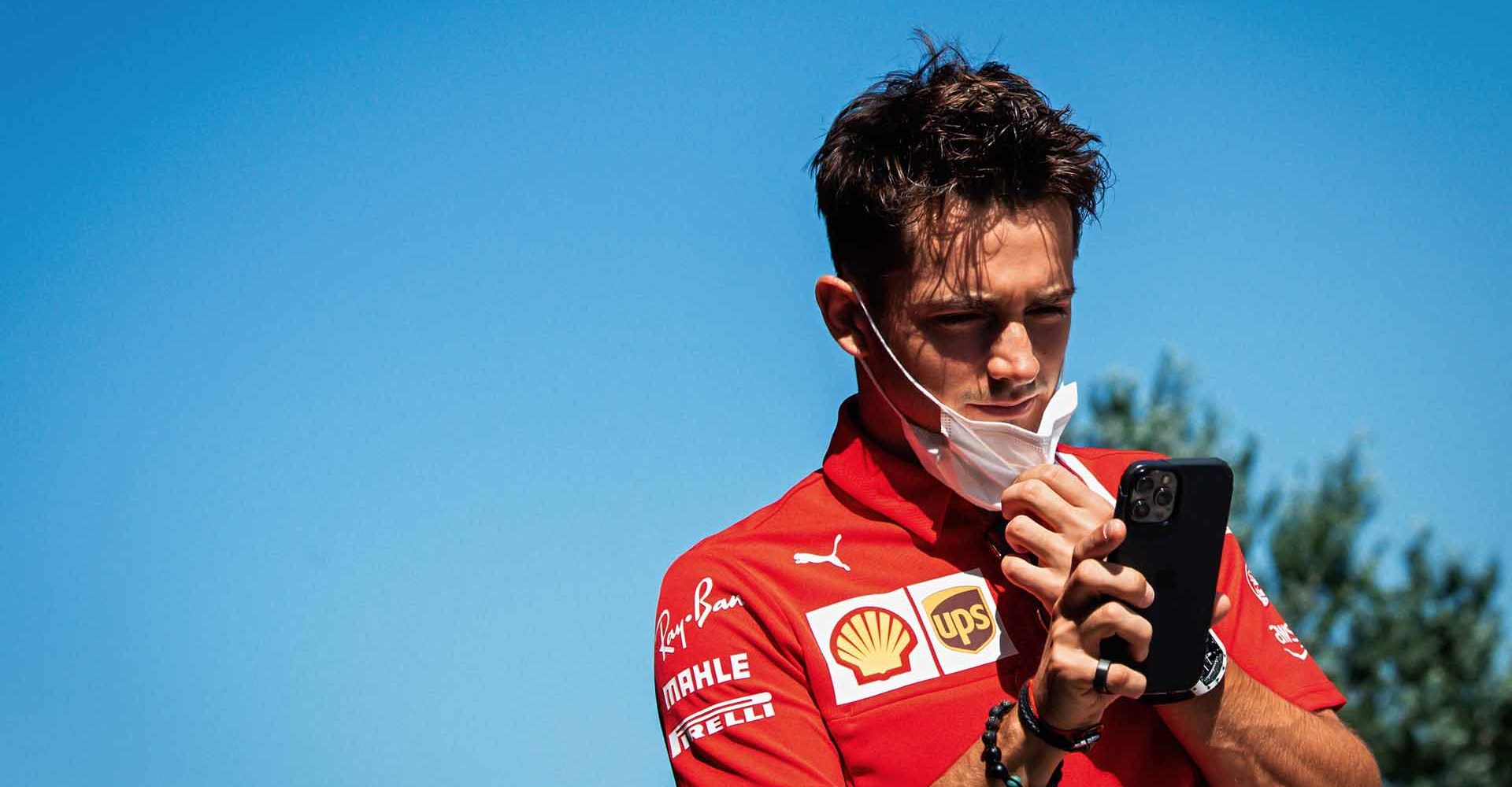 Charles Leclerc Ferrari looks his smartphone