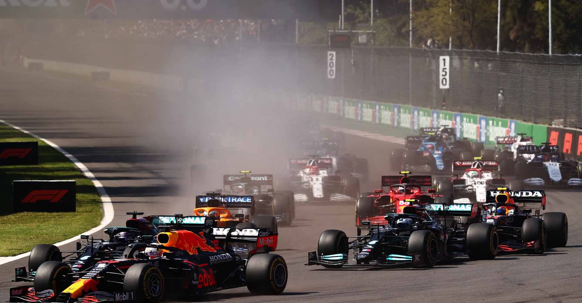 MEXICO CITY, MEXICO - NOVEMBER 07: Max Verstappen of the Netherlands driving the (33) Red Bull Racing RB16B Honda leads Lewis Hamilton of Great Britain driving the (44) Mercedes AMG Petronas F1 Team Mercedes W12 and the rest of the field at the start during the F1 Grand Prix of Mexico at Autodromo Hermanos Rodriguez on November 07, 2021 in Mexico City, Mexico. (Photo by Mark Thompson/Getty Images)