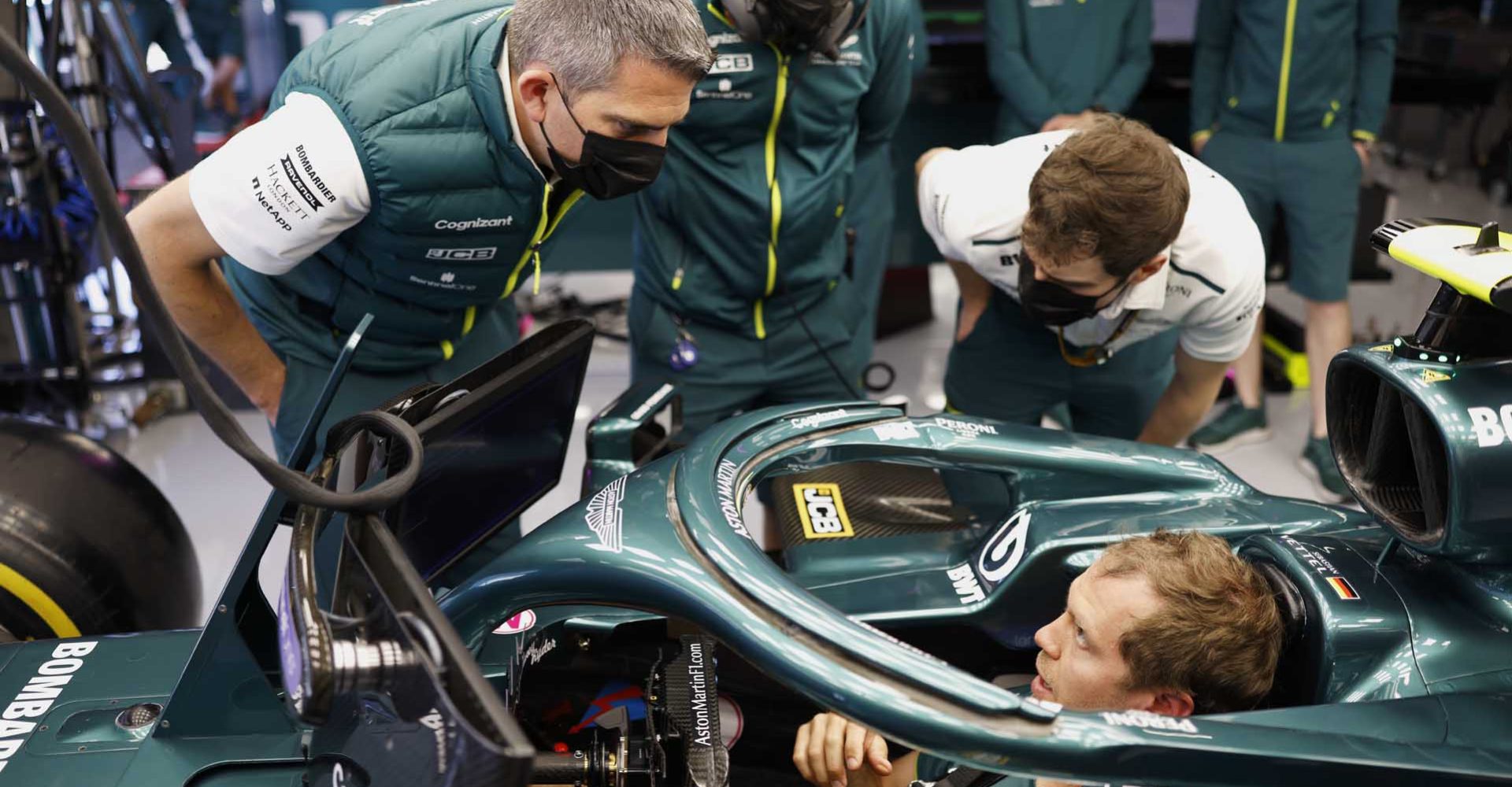 Sebastian Vettel, Aston Martin AMR21, taks to members of the team in the garage