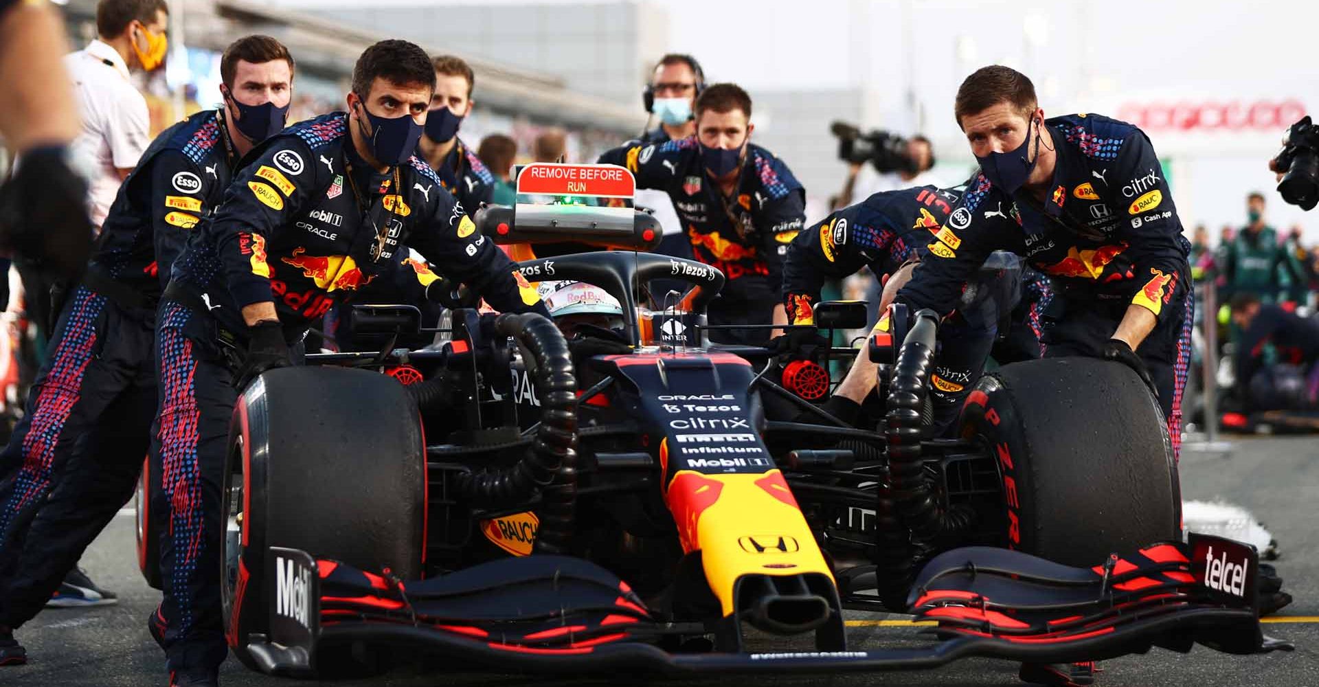 DOHA, QATAR - NOVEMBER 21: Red Bull Racing team members push the car of Max Verstappen of the Netherlands and Red Bull Racing into position on the gird before the F1 Grand Prix of Qatar at Losail International Circuit on November 21, 2021 in Doha, Qatar. (Photo by Mark Thompson/Getty Images)