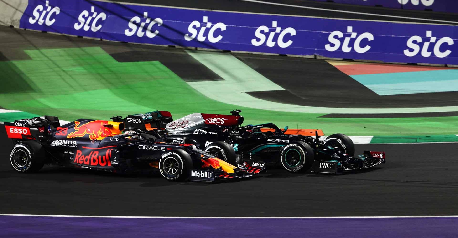 JEDDAH, SAUDI ARABIA - DECEMBER 05: Max Verstappen of the Netherlands driving the (33) Red Bull Racing RB16B Honda and Lewis Hamilton of Great Britain driving the (44) Mercedes AMG Petronas F1 Team Mercedes W12 battle for track position at the restart during the F1 Grand Prix of Saudi Arabia at Jeddah Corniche Circuit on December 05, 2021 in Jeddah, Saudi Arabia. (Photo by Mark Thompson/Getty Images)