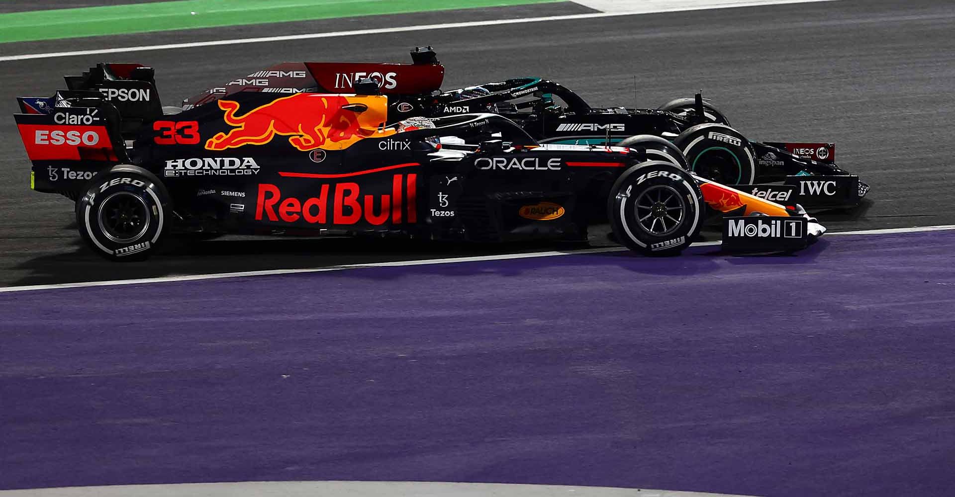 JEDDAH, SAUDI ARABIA - DECEMBER 05: Max Verstappen of the Netherlands driving the (33) Red Bull Racing RB16B Honda and Lewis Hamilton of Great Britain driving the (44) Mercedes AMG Petronas F1 Team Mercedes W12 battle for track position at the restart during the F1 Grand Prix of Saudi Arabia at Jeddah Corniche Circuit on December 05, 2021 in Jeddah, Saudi Arabia. (Photo by Mark Thompson/Getty Images)