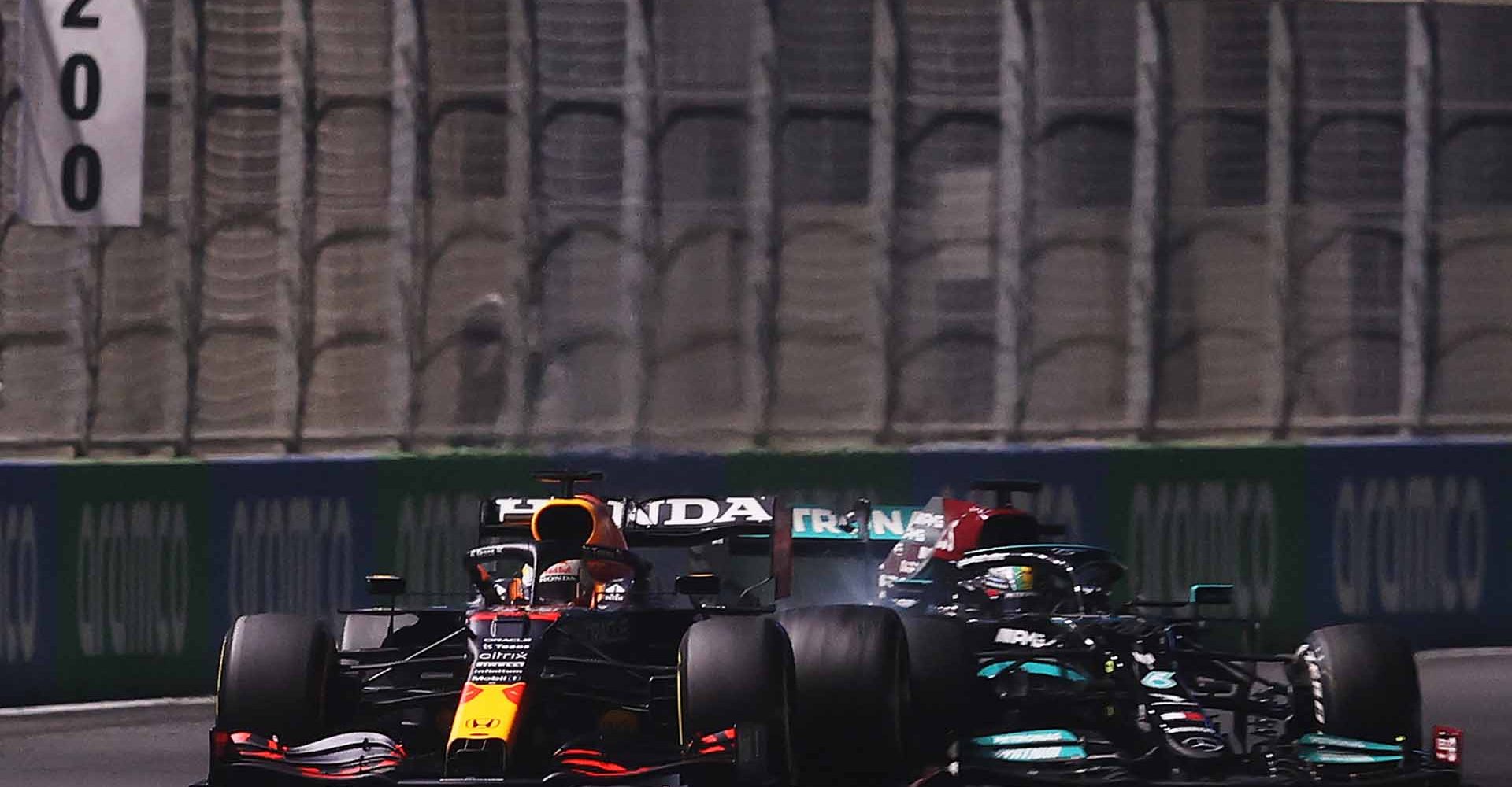 JEDDAH, SAUDI ARABIA - DECEMBER 05: Max Verstappen of the Netherlands driving the (33) Red Bull Racing RB16B Honda and Lewis Hamilton of Great Britain driving the (44) Mercedes AMG Petronas F1 Team Mercedes W12 collide during the F1 Grand Prix of Saudi Arabia at Jeddah Corniche Circuit on December 05, 2021 in Jeddah, Saudi Arabia. (Photo by Lars Baron/Getty Images)