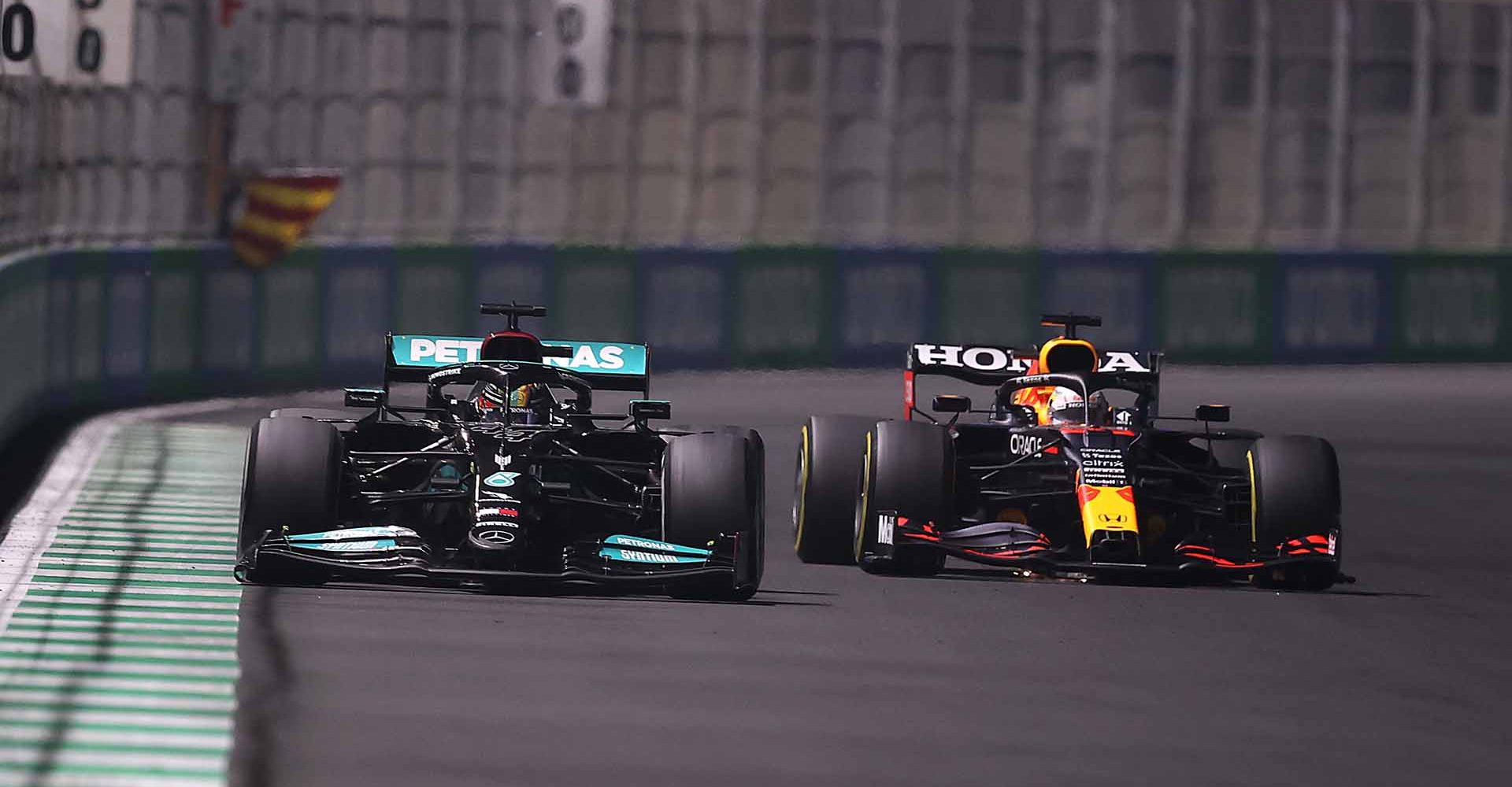 JEDDAH, SAUDI ARABIA - DECEMBER 05: Max Verstappen of the Netherlands driving the (33) Red Bull Racing RB16B Honda and Lewis Hamilton of Great Britain driving the (44) Mercedes AMG Petronas F1 Team Mercedes W12 during the F1 Grand Prix of Saudi Arabia at Jeddah Corniche Circuit on December 05, 2021 in Jeddah, Saudi Arabia. (Photo by Lars Baron/Getty Images)