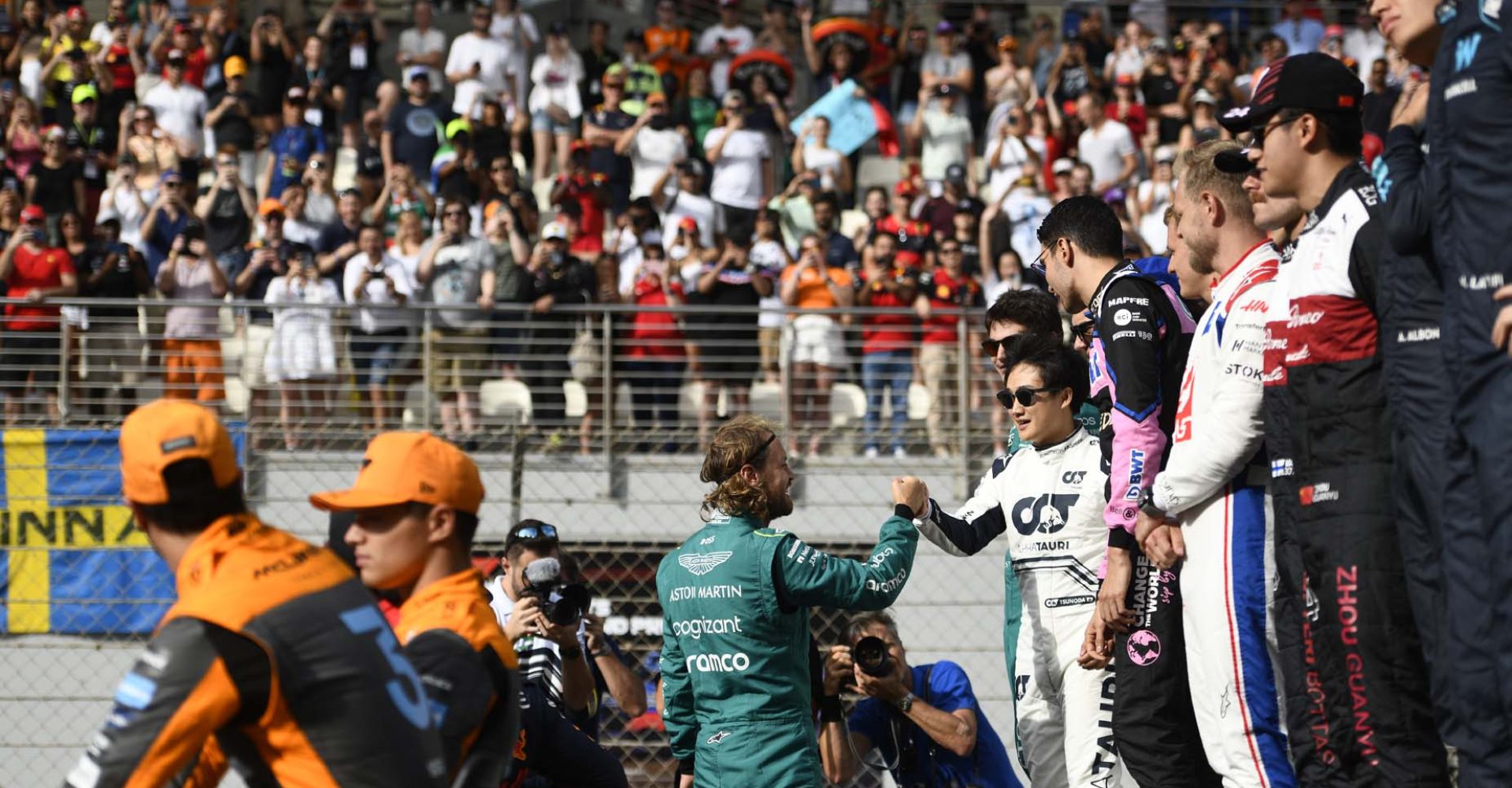 ABU DHABI, UNITED ARAB EMIRATES - NOVEMBER 20: Sebastian Vettel of Germany and Aston Martin F1 Team is greeted by Yuki Tsunoda of Japan and Scuderia AlphaTauri as they prepare for the F1 2022 End of Year photo prior to the F1 Grand Prix of Abu Dhabi at Yas Marina Circuit on November 20, 2022 in Abu Dhabi, United Arab Emirates. (Photo by Rudy Carezzevoli/Getty Images)