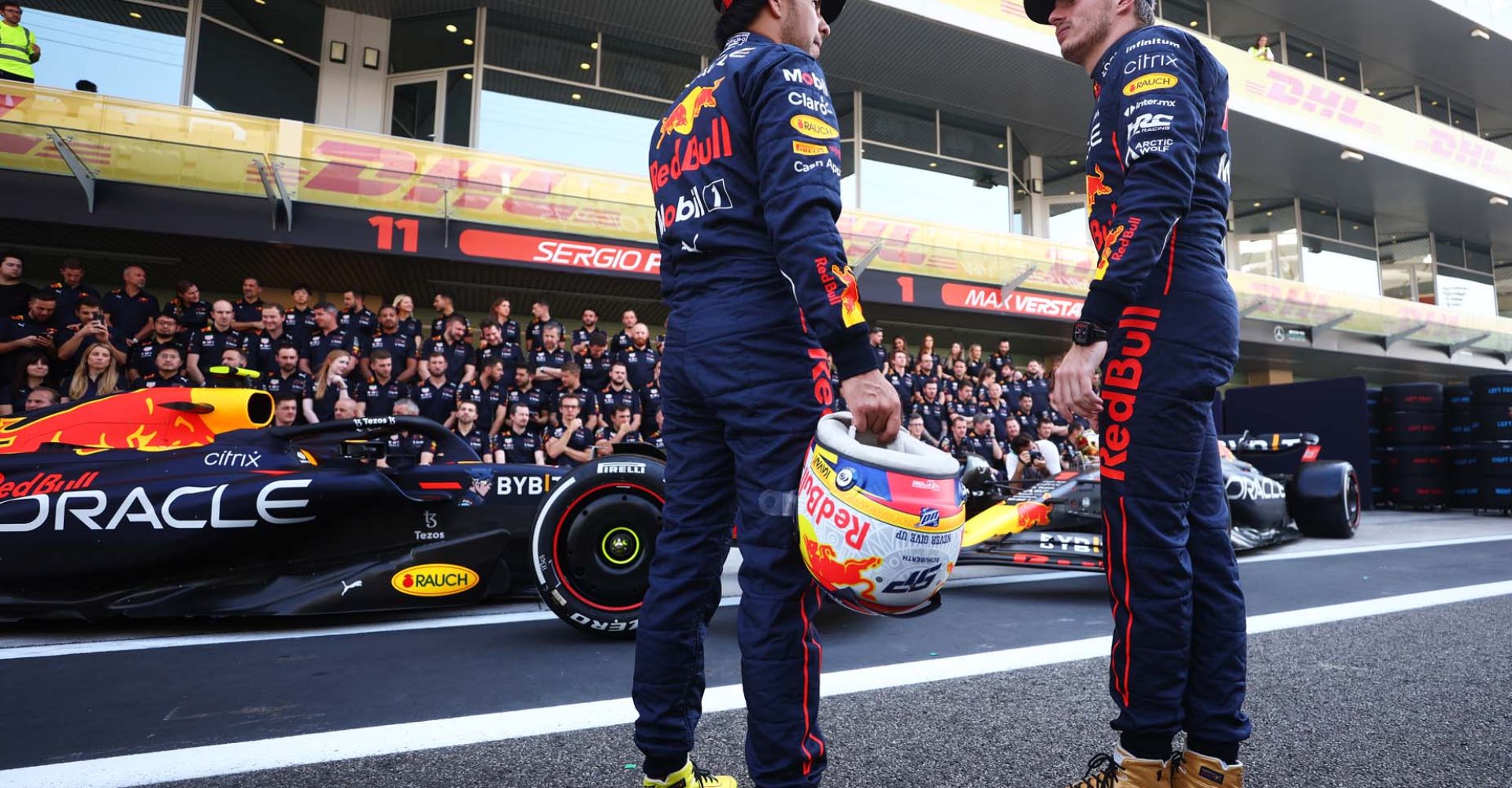 ABU DHABI, UNITED ARAB EMIRATES - NOVEMBER 17: Max Verstappen of the Netherlands and Oracle Red Bull Racing and Sergio Perez of Mexico and Oracle Red Bull Racing talk ahead of the Red Bull Racing end of season team photo during previews ahead of the F1 Grand Prix of Abu Dhabi at Yas Marina Circuit on November 17, 2022 in Abu Dhabi, United Arab Emirates. (Photo by Bryn Lennon/Getty Images)