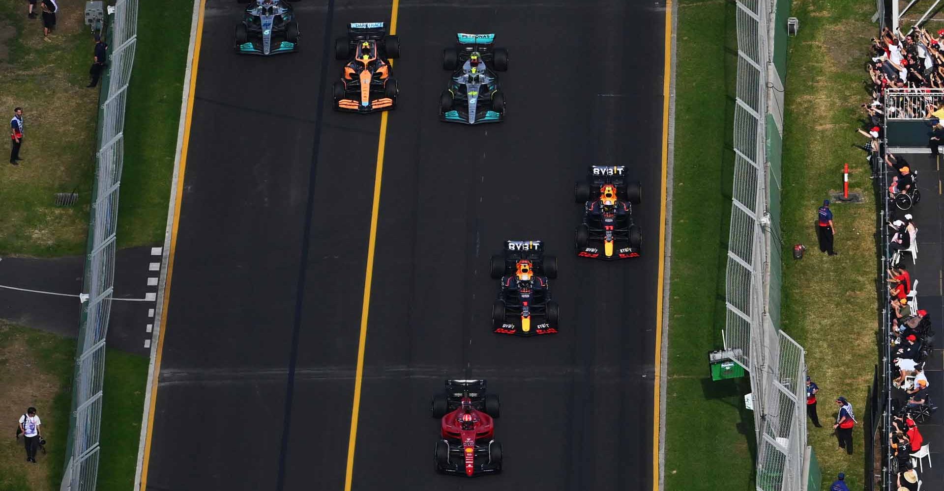 MELBOURNE, AUSTRALIA - APRIL 10: Charles Leclerc of Monaco driving (16) the Ferrari F1-75 leads Max Verstappen of the Netherlands driving the (1) Oracle Red Bull Racing RB18, Sergio Perez of Mexico driving the (11) Oracle Red Bull Racing RB18, Lewis Hamilton of Great Britain driving the (44) Mercedes AMG Petronas F1 Team W13, Lando Norris of Great Britain driving the (4) McLaren MCL36 Mercedes and George Russell of Great Britain driving the (63) Mercedes AMG Petronas F1 Team W13 at the start during the F1 Grand Prix of Australia at Melbourne Grand Prix Circuit on April 10, 2022 in Melbourne, Australia. (Photo by Clive Mason/Getty Images)