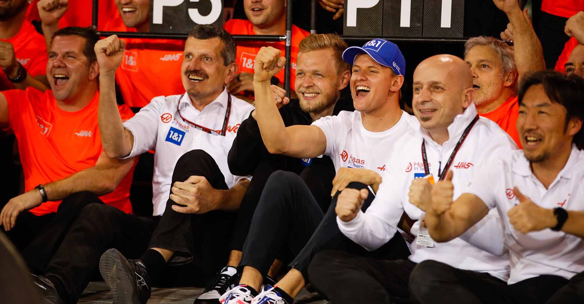 BAHRAIN INTERNATIONAL CIRCUIT, BAHRAIN - MARCH 20: Guenther Steiner, Team Principal, Haas F1, Kevin Magnussen, Haas F1 Team, Mick Schumacher, Haas F1 Team, and the Haas team celebrate after the race during the Bahrain GP at Bahrain International Circuit on Sunday March 20, 2022 in Sakhir, Bahrain. (Photo by Zak Mauger / LAT Images)