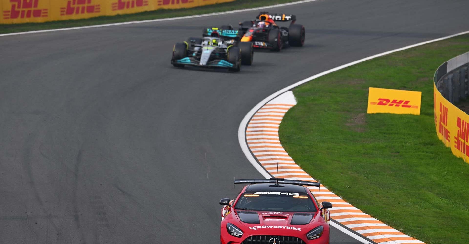 ZANDVOORT, NETHERLANDS - SEPTEMBER 04: The FIA safety car leads Lewis Hamilton of Great Britain driving the (44) Mercedes AMG Petronas F1 Team W13 and Max Verstappen of the Netherlands driving the (1) Oracle Red Bull Racing RB18 during the F1 Grand Prix of The Netherlands at Circuit Zandvoort on September 04, 2022 in Zandvoort, Netherlands. (Photo by Clive Mason/Getty Images)