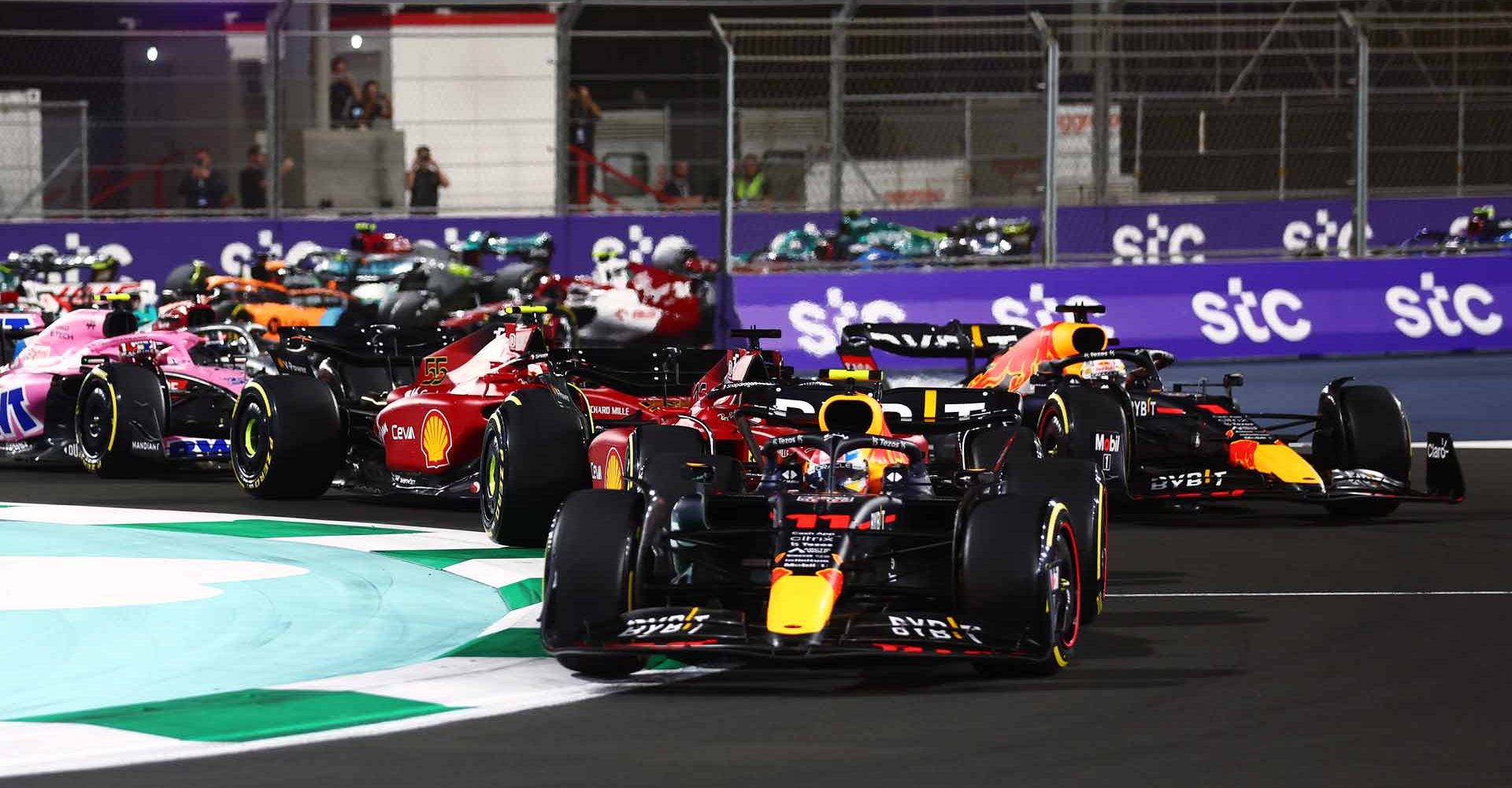 JEDDAH, SAUDI ARABIA - MARCH 27: Sergio Perez of Mexico driving the (11) Oracle Red Bull Racing RB18 leads Charles Leclerc of Monaco driving (16) the Ferrari F1-75 and the rest of the field at the start during the F1 Grand Prix of Saudi Arabia at the Jeddah Corniche Circuit on March 27, 2022 in Jeddah, Saudi Arabia. (Photo by Mark Thompson/Getty Images)