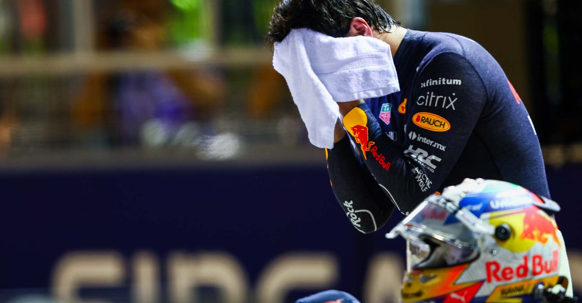 SINGAPORE, SINGAPORE - OCTOBER 01: Second placed qualifier Sergio Perez of Mexico and Oracle Red Bull Racing wipes his face in parc ferme during qualifying ahead of the F1 Grand Prix of Singapore at Marina Bay Street Circuit on October 01, 2022 in Singapore, Singapore. (Photo by Mark Thompson/Getty Images,)