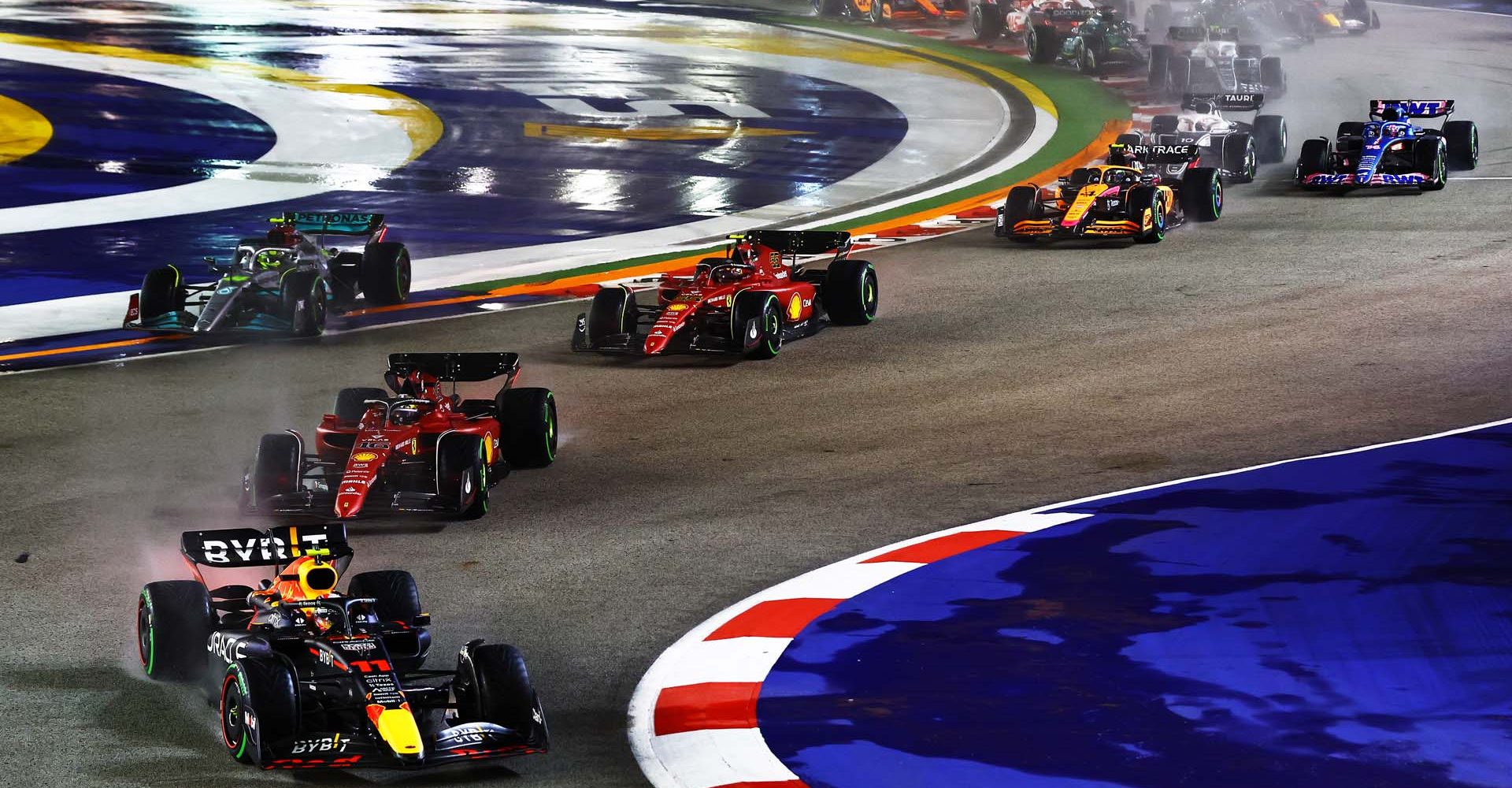 SINGAPORE, SINGAPORE - OCTOBER 02: Sergio Perez of Mexico driving the (11) Oracle Red Bull Racing RB18 leads Charles Leclerc of Monaco driving the (16) Ferrari F1-75 and the rest of the field at the start during the F1 Grand Prix of Singapore at Marina Bay Street Circuit on October 02, 2022 in Singapore, Singapore. (Photo by Mark Thompson/Getty Images,)