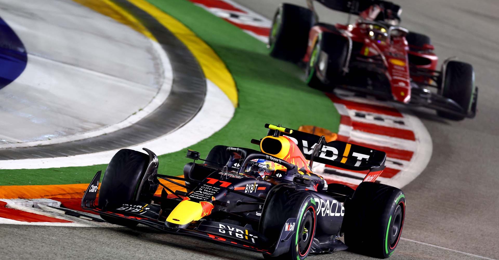 SINGAPORE, SINGAPORE - OCTOBER 02: Sergio Perez of Mexico driving the (11) Oracle Red Bull Racing RB18 leads Charles Leclerc of Monaco driving the (16) Ferrari F1-75 during the F1 Grand Prix of Singapore at Marina Bay Street Circuit on October 02, 2022 in Singapore, Singapore. (Photo by Mark Thompson/Getty Images,)