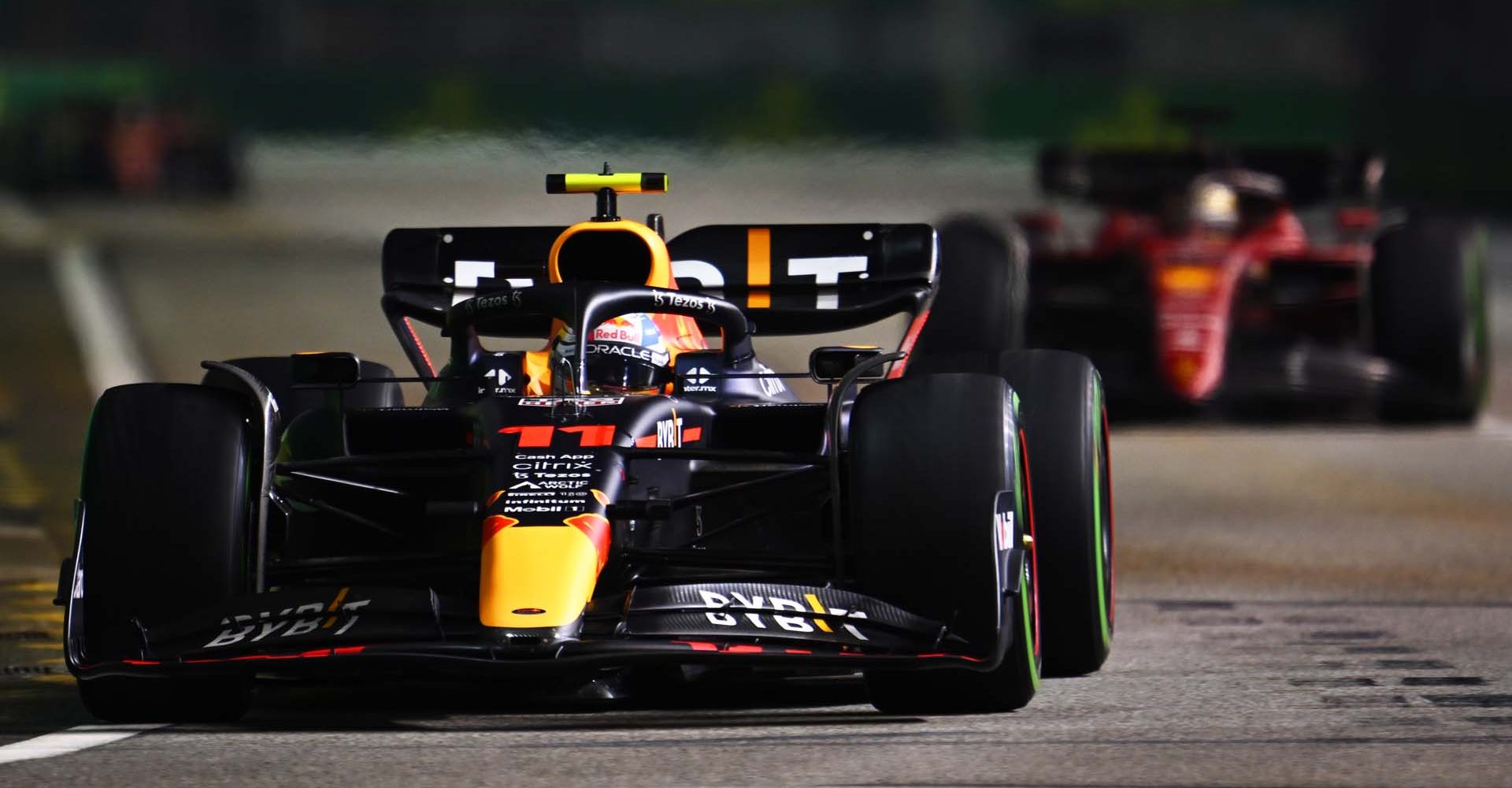 SINGAPORE, SINGAPORE - OCTOBER 02: Sergio Perez of Mexico driving the (11) Oracle Red Bull Racing RB18 leads Charles Leclerc of Monaco driving the (16) Ferrari F1-75 during the F1 Grand Prix of Singapore at Marina Bay Street Circuit on October 02, 2022 in Singapore, Singapore. (Photo by Clive Mason/Getty Images,)