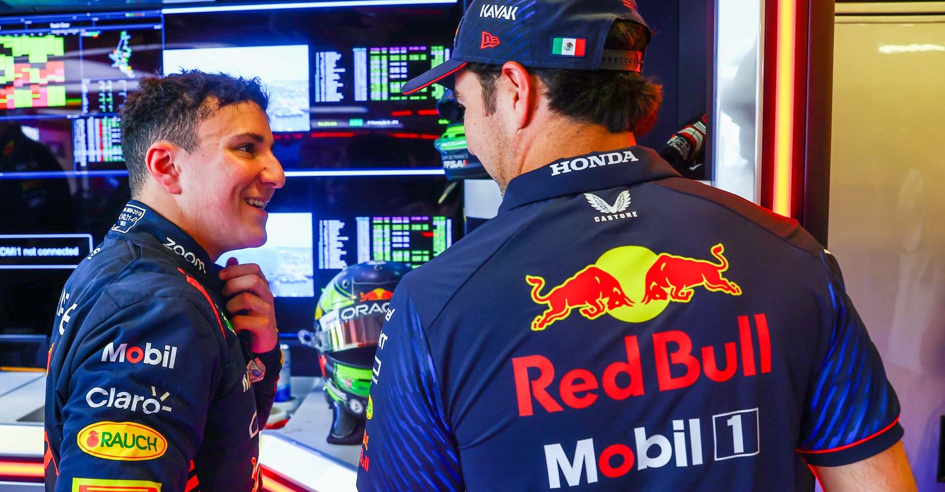 ABU DHABI, UNITED ARAB EMIRATES - NOVEMBER 24: Isack Hadjar of France and Red Bull Racing talks with Sergio Perez of Mexico and Oracle Red Bull Racing in the garage during practice ahead of the F1 Grand Prix of Abu Dhabi at Yas Marina Circuit on November 24, 2023 in Abu Dhabi, United Arab Emirates. (Photo by Mark Thompson/Getty Images) // Getty Images / Red Bull Content Pool // SI202311241169 // Usage for editorial use only //