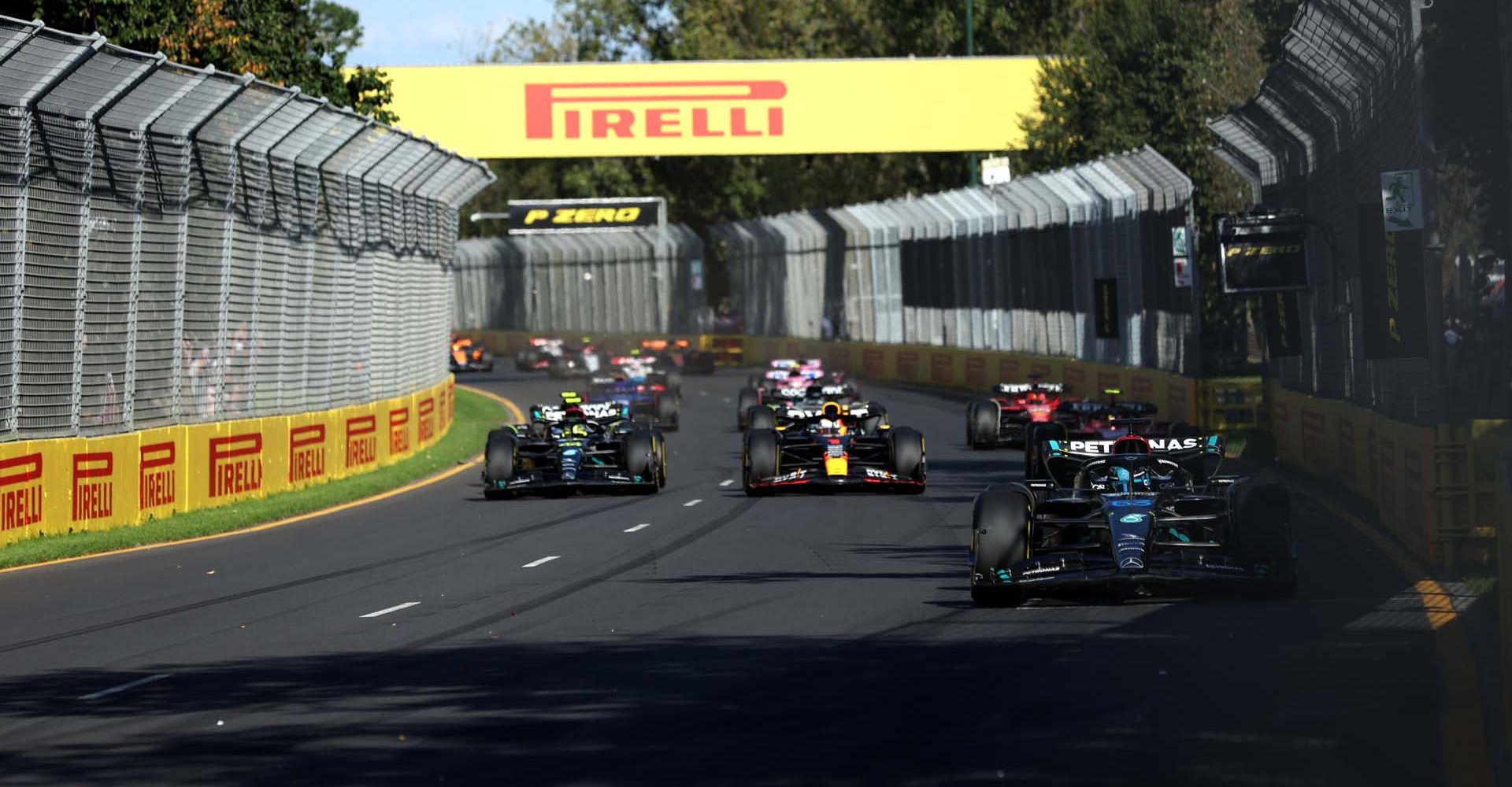 MELBOURNE GRAND PRIX CIRCUIT, AUSTRALIA - APRIL 02: George Russell, Mercedes F1 W14, leads Max Verstappen, Red Bull Racing RB19, Sir Lewis Hamilton, Mercedes F1 W14, and the rest of the field on the opening lap during the Australian GP at Melbourne Grand Prix Circuit on Sunday April 02, 2023 in Melbourne, Australia. (Photo by Lionel Ng / LAT Images)