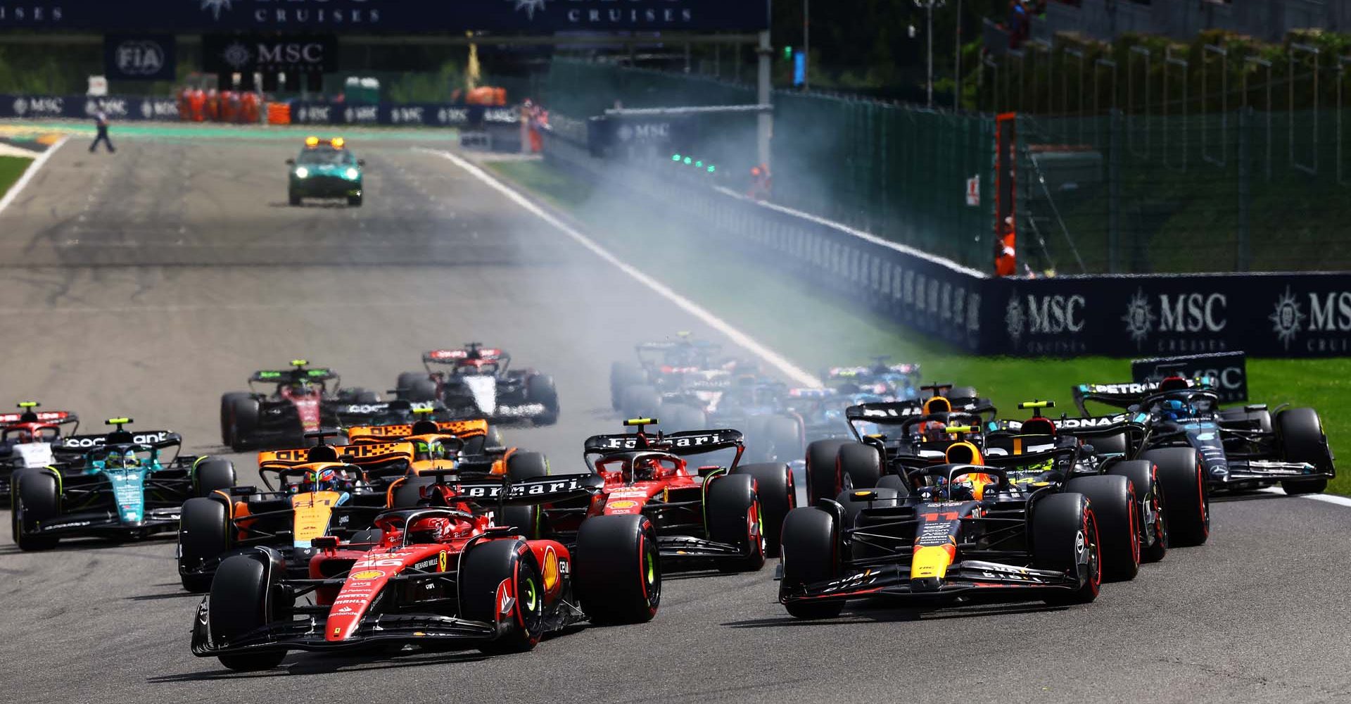 SPA, BELGIUM - JULY 30: Charles Leclerc of Monaco driving the (16) Ferrari SF-23 leads Sergio Perez of Mexico driving the (11) Oracle Red Bull Racing RB19 and the rest of the field into turn one at the start during the F1 Grand Prix of Belgium at Circuit de Spa-Francorchamps on July 30, 2023 in Spa, Belgium. (Photo by Mark Thompson/Getty Images)