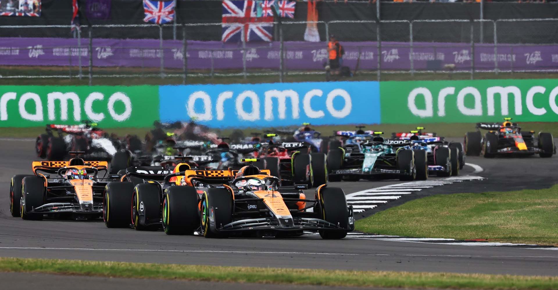 Lando Norris, McLaren MCL60, leads Max Verstappen, Red Bull Racing RB19, Oscar Piastri, McLaren MCL60, Charles Leclerc, Ferrari SF-23, George Russell, Mercedes F1 W14, and the rest of the field at the start