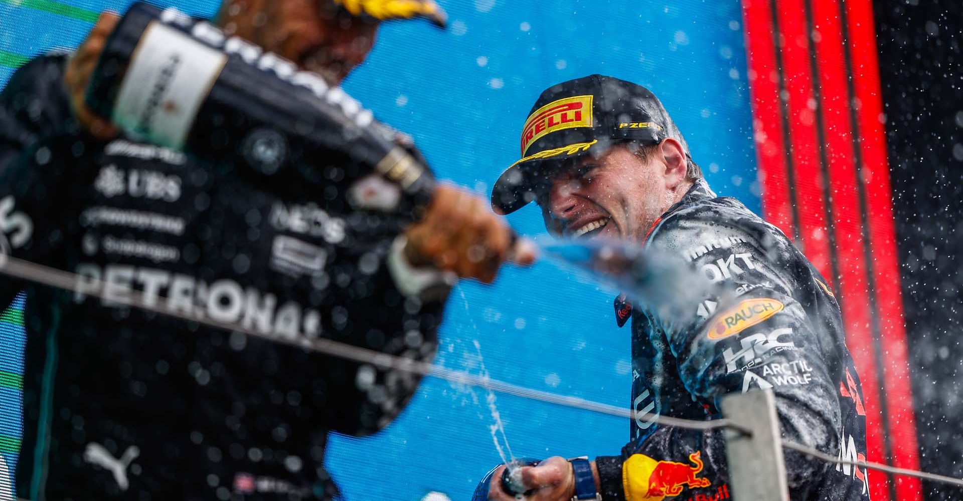 SILVERSTONE CIRCUIT, UNITED KINGDOM - JULY 09: Sir Lewis Hamilton, Mercedes-AMG, 3rd position, and Max Verstappen, Red Bull Racing, 1st position, spray Champagne during the British GP at Silverstone Circuit on Sunday July 09, 2023 in Northamptonshire, United Kingdom. (Photo by Andy Hone / LAT Images)