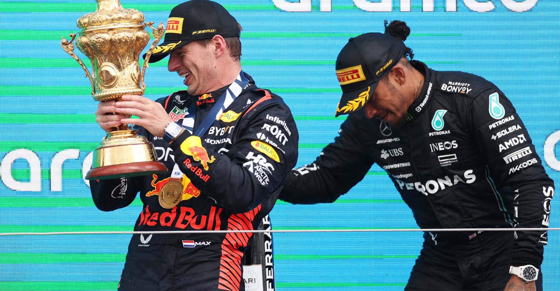 NORTHAMPTON, ENGLAND - JULY 09: Race winner Max Verstappen of the Netherlands and Oracle Red Bull Racing and third placed Lewis Hamilton of Great Britain and Mercedes celebrateon the podium during the F1 Grand Prix of Great Britain at Silverstone Circuit on July 09, 2023 in Northampton, England. (Photo by Ryan Pierse/Getty Images)