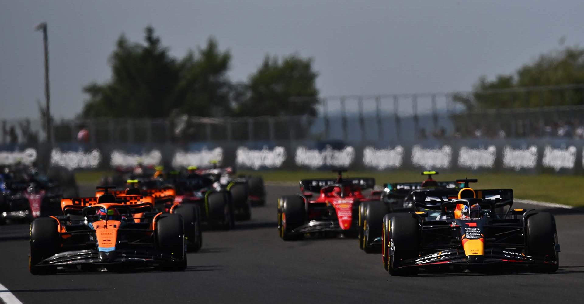 BUDAPEST, HUNGARY - JULY 23: Max Verstappen of the Netherlands driving the (1) Oracle Red Bull Racing RB19 leads Oscar Piastri of Australia at the start driving the (81) McLaren MCL60 Mercedes during the F1 Grand Prix of Hungary at Hungaroring on July 23, 2023 in Budapest, Hungary. (Photo by Dan Mullan/Getty Images)