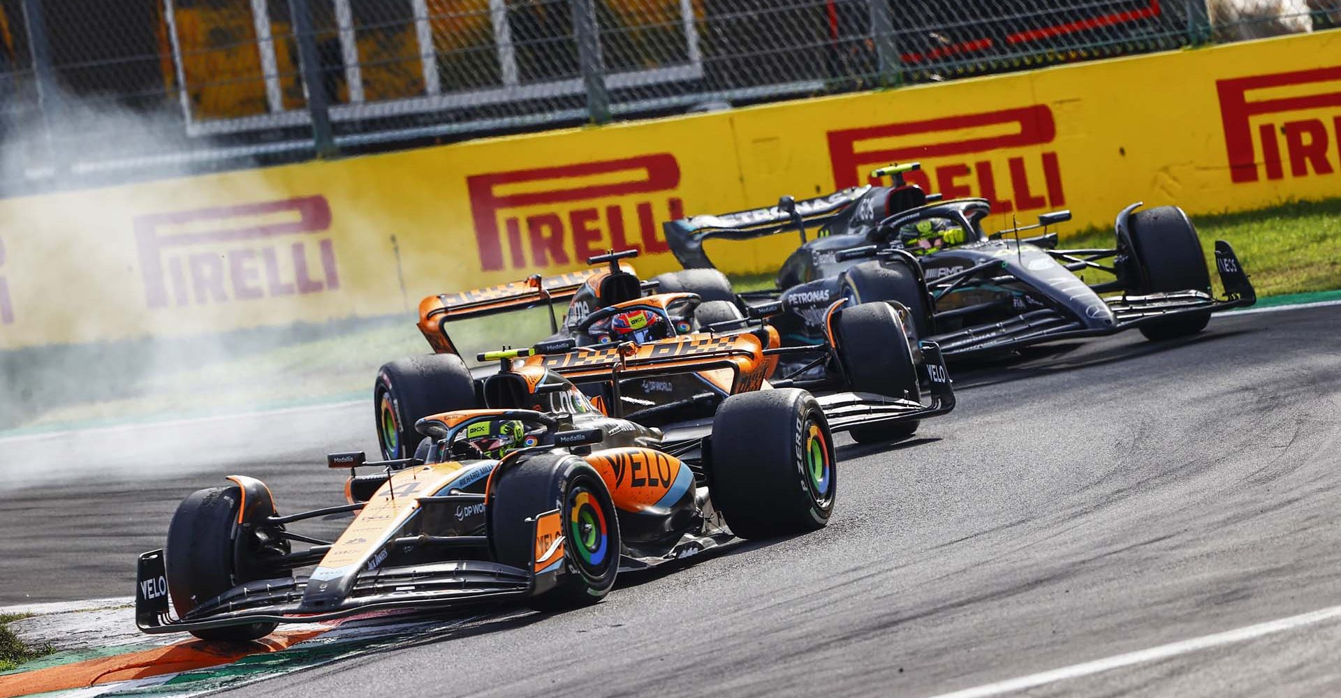 Lando Norris, McLaren MCL60, leads Oscar Piastri, McLaren MCL60, and Sir Lewis Hamilton, Mercedes F1 W14