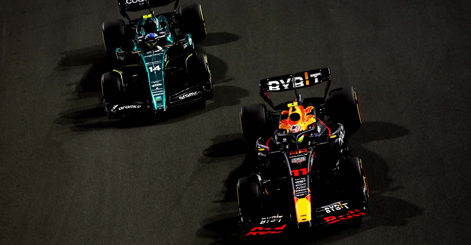 JEDDAH, SAUDI ARABIA - MARCH 19: Sergio Perez of Mexico driving the (11) Oracle Red Bull Racing RB19 leads Fernando Alonso of Spain driving the (14) Aston Martin AMR23 Mercedes during the F1 Grand Prix of Saudi Arabia at Jeddah Corniche Circuit on March 19, 2023 in Jeddah, Saudi Arabia. (Photo by Lars Baron/Getty Images)