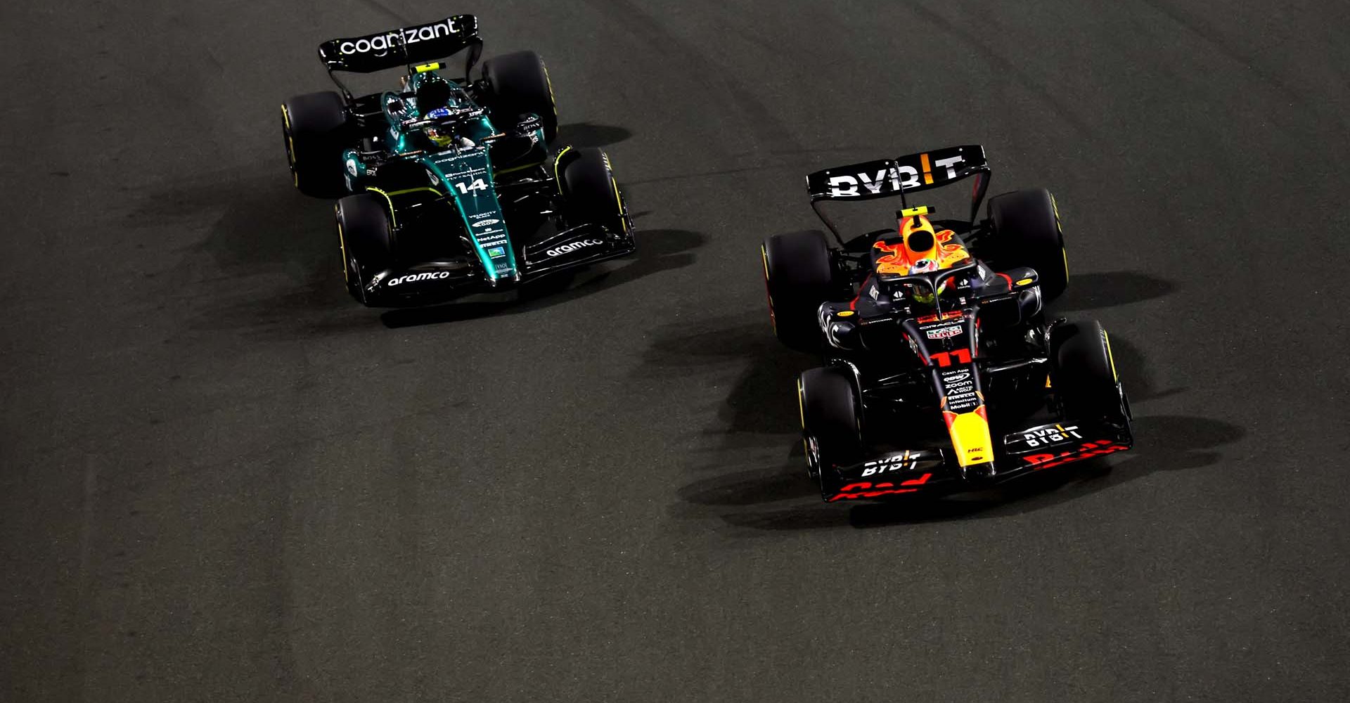 JEDDAH, SAUDI ARABIA - MARCH 19: Sergio Perez of Mexico driving the (11) Oracle Red Bull Racing RB19 leads Fernando Alonso of Spain driving the (14) Aston Martin AMR23 Mercedes during the F1 Grand Prix of Saudi Arabia at Jeddah Corniche Circuit on March 19, 2023 in Jeddah, Saudi Arabia. (Photo by Lars Baron/Getty Images)