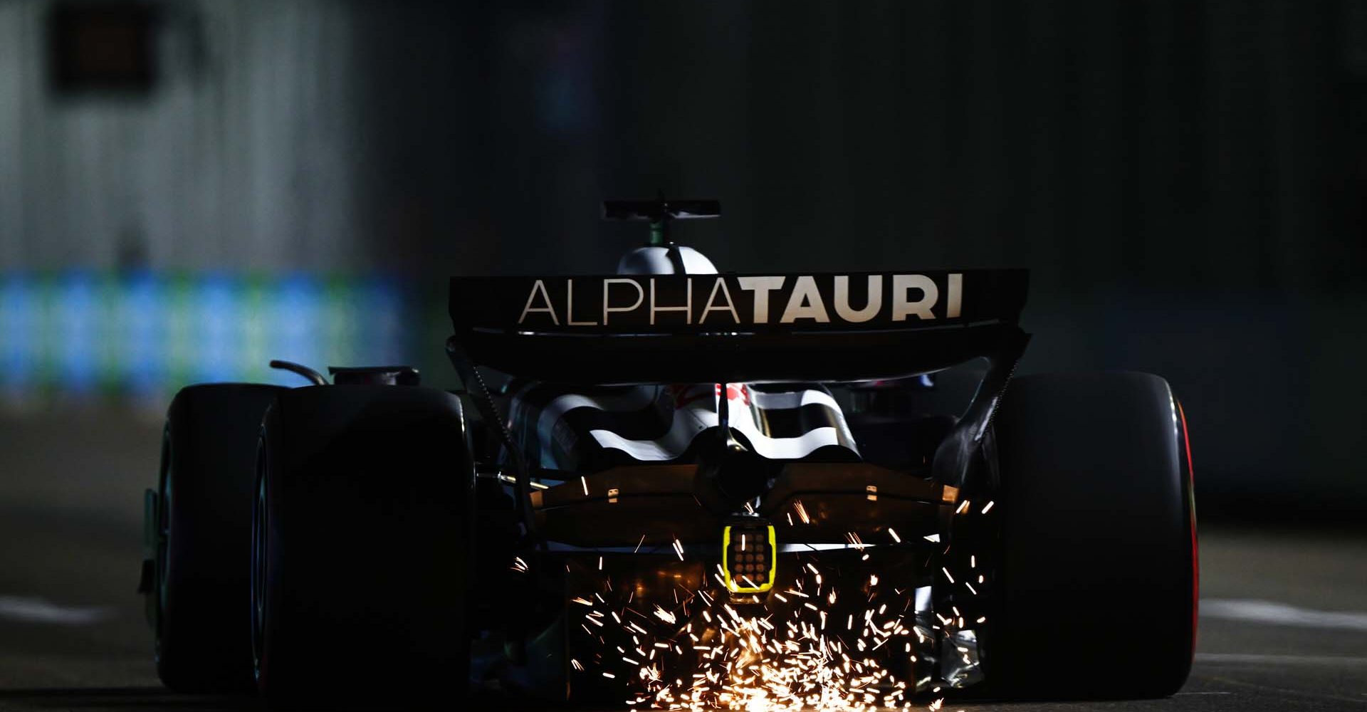 SINGAPORE, SINGAPORE - SEPTEMBER 16: Sparks fly behind the car of Liam Lawson of New Zealand driving the (40) Scuderia AlphaTauri AT04 during qualifying ahead of the F1 Grand Prix of Singapore at Marina Bay Street Circuit on September 16, 2023 in Singapore, Singapore. (Photo by Clive Mason/Getty Images) // Getty Images / Red Bull Content Pool // SI202309160523 // Usage for editorial use only //