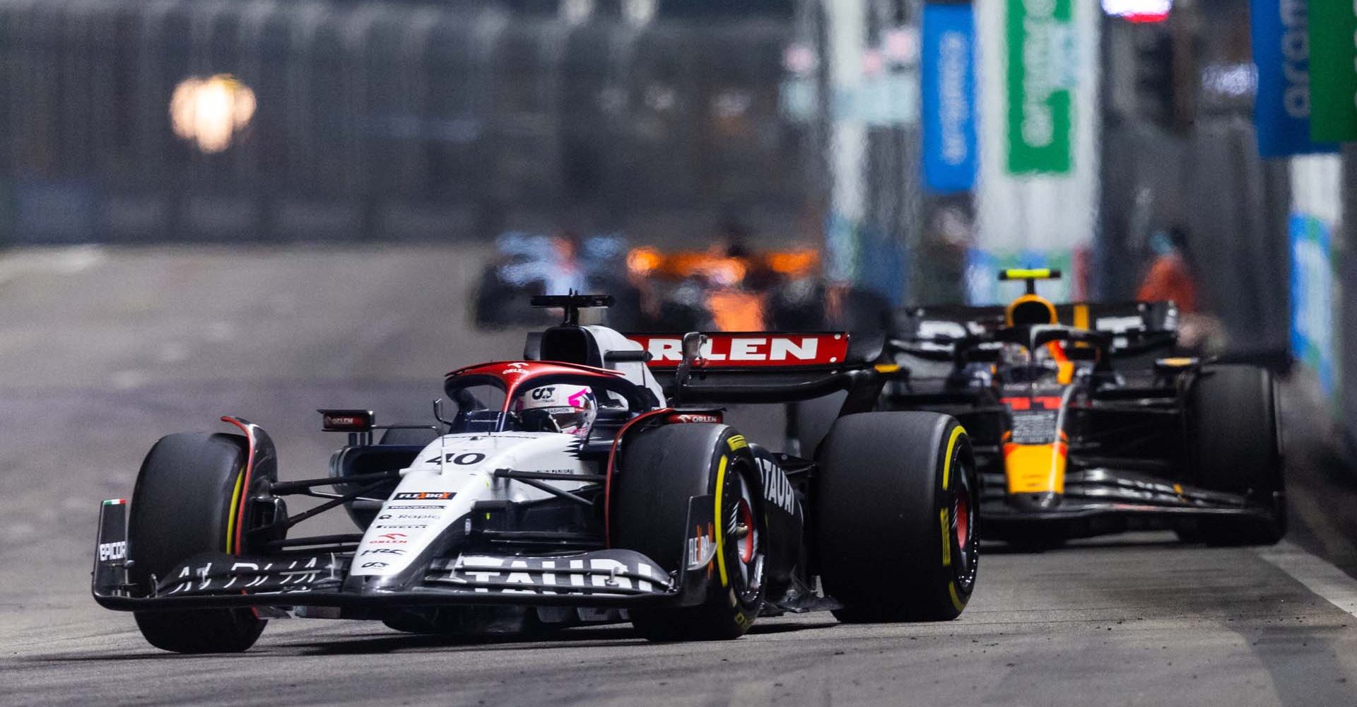 SINGAPORE, SINGAPORE - SEPTEMBER 17: Liam Lawson of New Zealand driving the (40) Scuderia AlphaTauri AT04 leads Sergio Perez of Mexico driving the (11) Oracle Red Bull Racing RB19 during the F1 Grand Prix of Singapore at Marina Bay Street Circuit on September 17, 2023 in Singapore, Singapore. (Photo by Clive Rose/Getty Images) // Getty Images / Red Bull Content Pool // SI202309170255 // Usage for editorial use only //