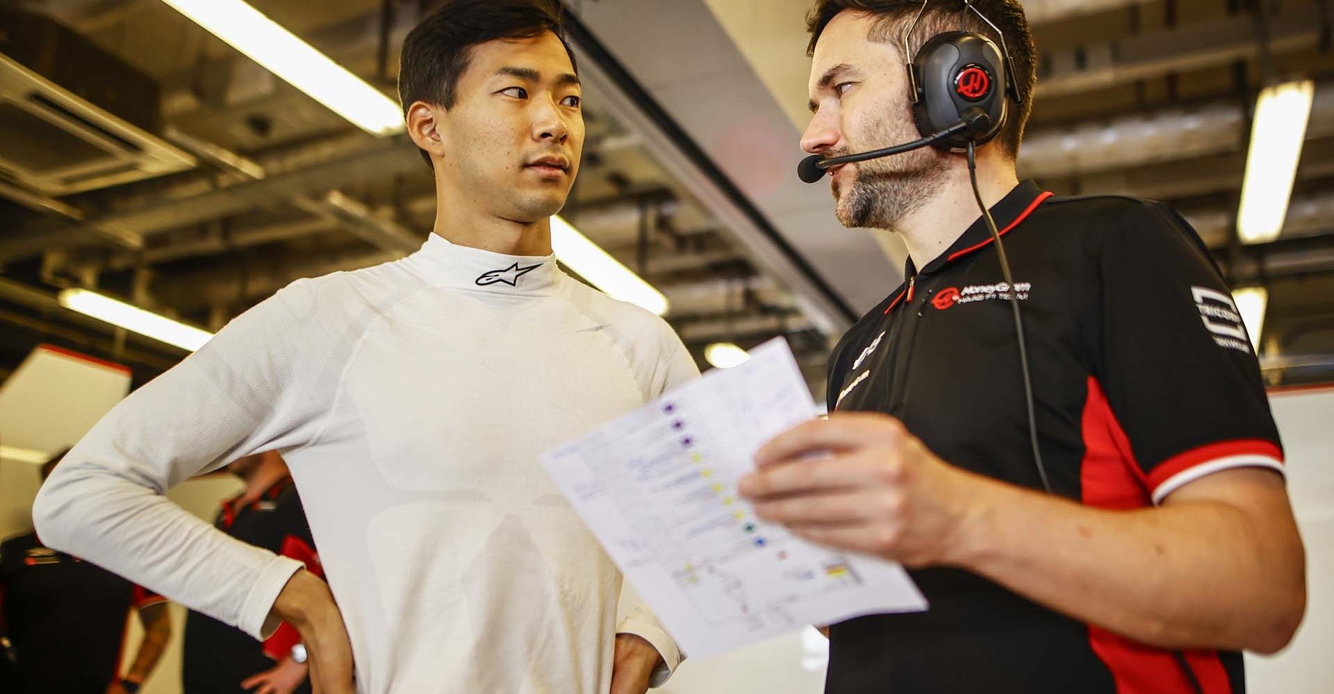 YAS MARINA CIRCUIT, UNITED ARAB EMIRATES - DECEMBER 10: Ryo Hirakawa, Haas F1 Team, with a teammate in the garage during the Abu Dhabi Post-Season Testing at Yas Marina Circuit on Tuesday December 10, 2024 in Abu Dhabi, United Arab Emirates. (Photo by Andy Hone / LAT Images)