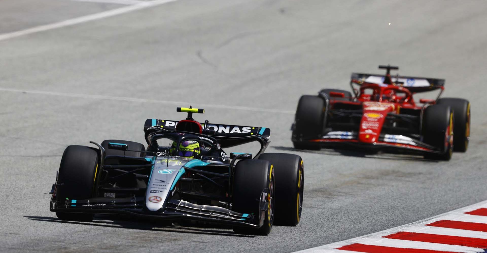 RED BULL RING, AUSTRIA - JUNE 29: Sir Lewis Hamilton, Mercedes F1 W15, leads Charles Leclerc, Ferrari SF-24 during the Austrian GP at Red Bull Ring on Saturday June 29, 2024 in Spielberg, Austria. (Photo by Andy Hone / LAT Images)