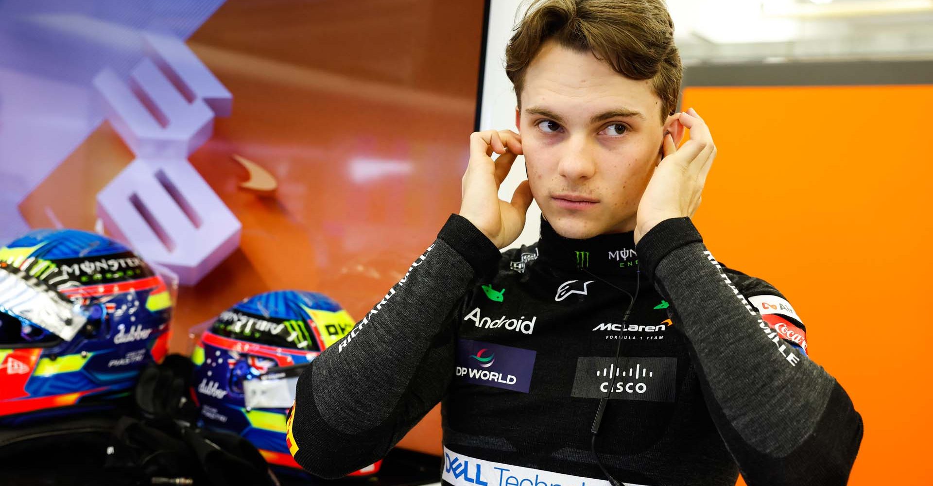 Oscar Piastri, McLaren F1 Team, adjusts his ear plugs in the team's garage