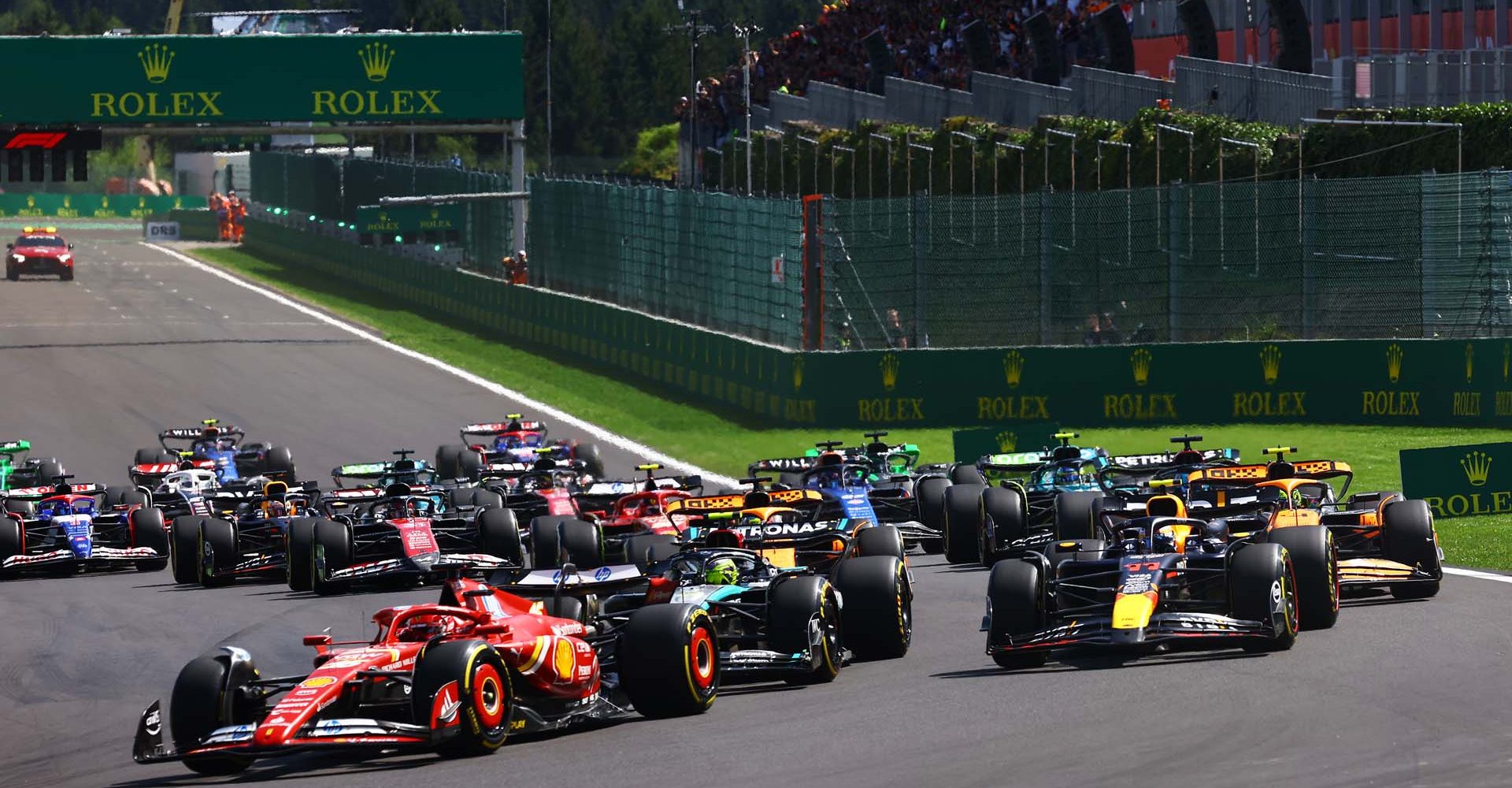 SPA, BELGIUM - JULY 28: Charles Leclerc of Monaco driving the (16) Ferrari SF-24 leads Sergio Perez of Mexico driving the (11) Oracle Red Bull Racing RB20 and the rest of the field round turn one at the start during the F1 Grand Prix of Belgium at Circuit de Spa-Francorchamps on July 28, 2024 in Spa, Belgium. (Photo by Mark Thompson/Getty Images) // Getty Images / Red Bull Content Pool // SI202407280368 // Usage for editorial use only //