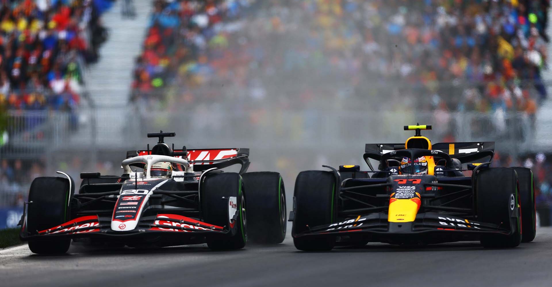 MONTREAL, QUEBEC - JUNE 09: Sergio Perez of Mexico driving the (11) Oracle Red Bull Racing RB20 and Kevin Magnussen of Denmark driving the (20) Haas F1 VF-24 Ferrari battle for position on track during the F1 Grand Prix of Canada at Circuit Gilles Villeneuve on June 09, 2024 in Montreal, Quebec. (Photo by Mark Thompson/Getty Images) // Getty Images / Red Bull Content Pool // SI202406090611 // Usage for editorial use only //