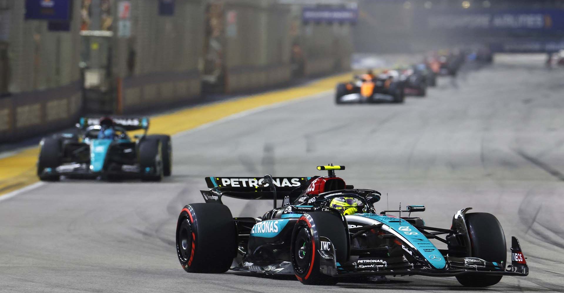 MARINA BAY STREET CIRCUIT, SINGAPORE - SEPTEMBER 22: Sir Lewis Hamilton, Mercedes F1 W15, leads George Russell, Mercedes F1 W15 during the Singapore GP at Marina Bay Street Circuit on Sunday September 22, 2024 in Singapore, Singapore. (Photo by Steven Tee / LAT Images)