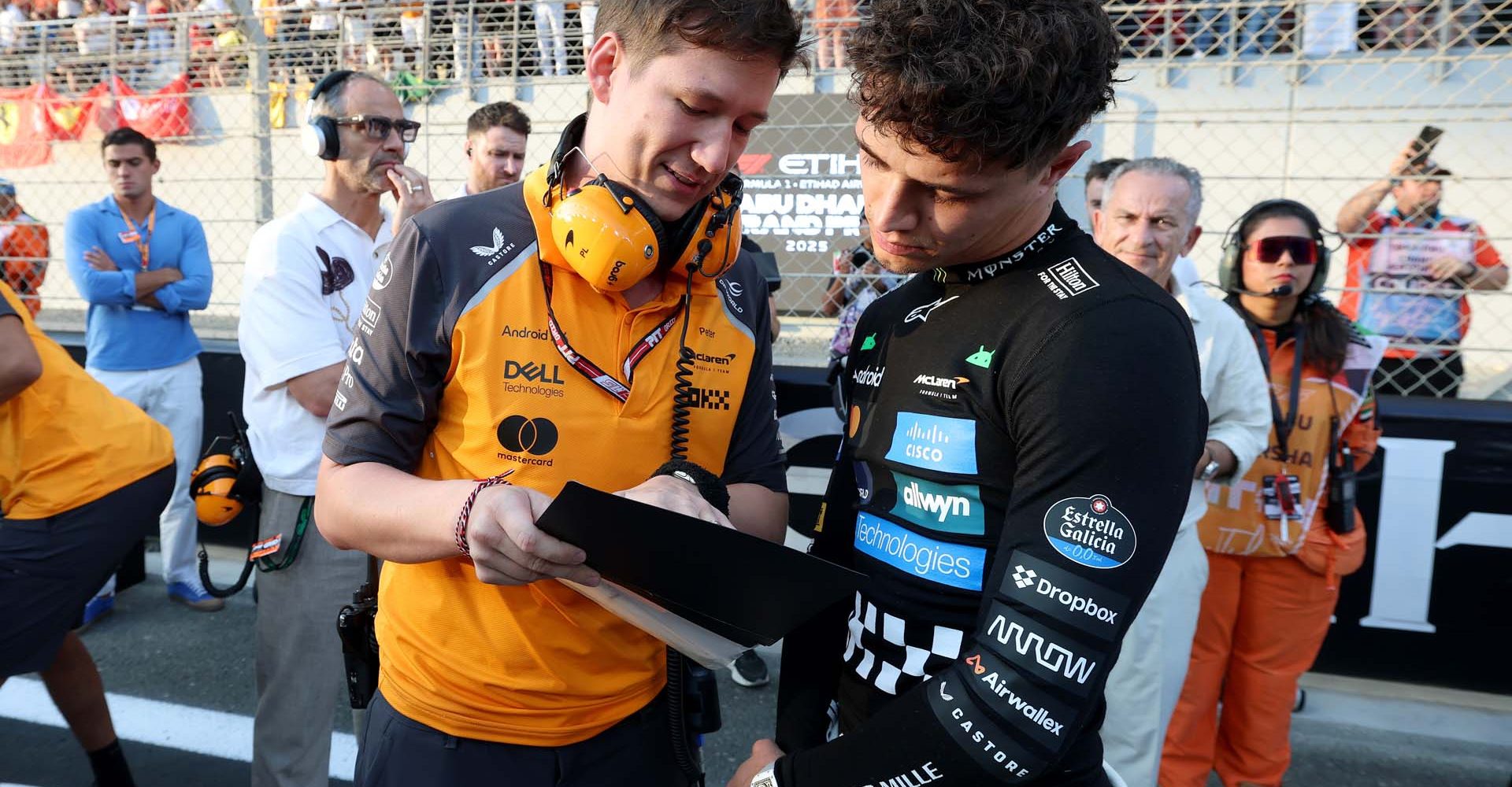ABU DHABI, UNITED ARAB EMIRATES - DECEMBER 07: Lando Norris of Great Britain and McLaren on the grid with an engineer (Péter Ladocsi) prior to the F1 Grand Prix of Abu Dhabi at Yas Marina Circuit on December 07, 2025 in Abu Dhabi, United Arab Emirates. (Photo by Steven Tee/LAT Images)
