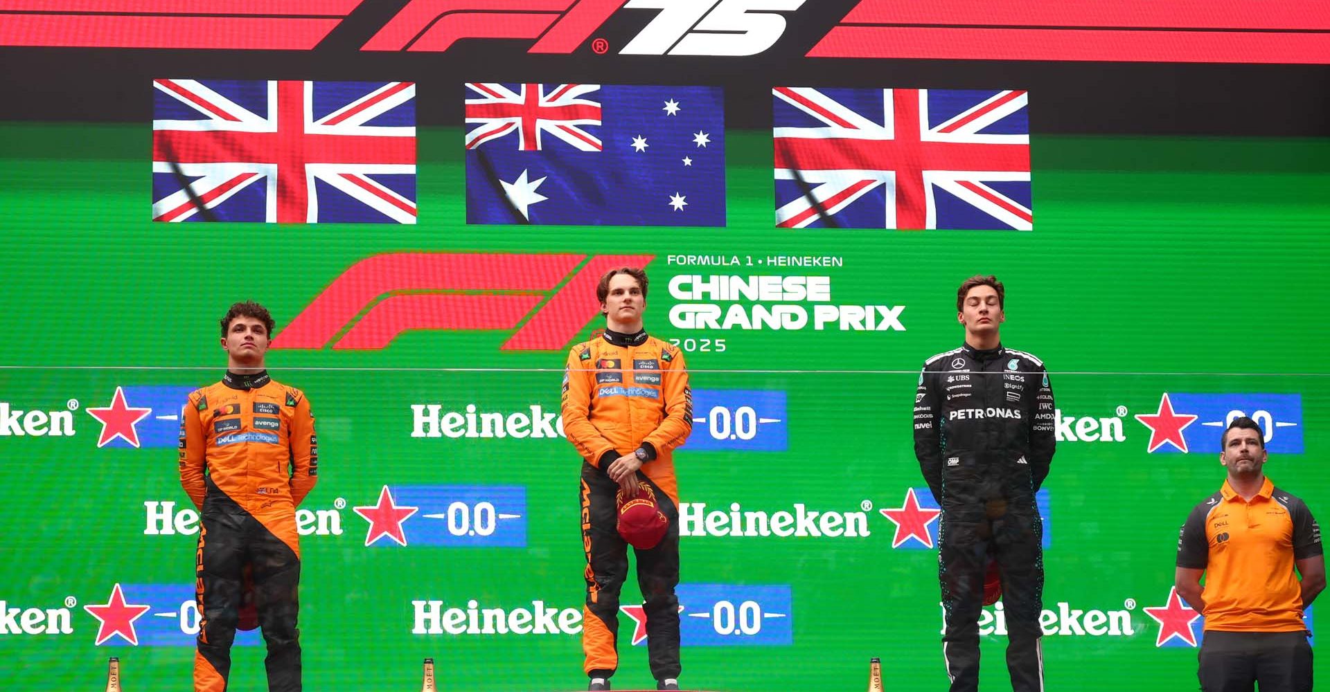 SHANGHAI, CHINA - MARCH 23: Second placed Lando Norris of Great Britain and McLaren Race winner Oscar Piastri of Australia and McLaren and Third placed George Russell of Great Britain and Mercedes AMG Petronas F1 Team on the podium during the F1 Grand Prix of China at Shanghai International Circuit on March 23, 2025 in Shanghai, China. (Photo by Clive Rose/Getty Images)