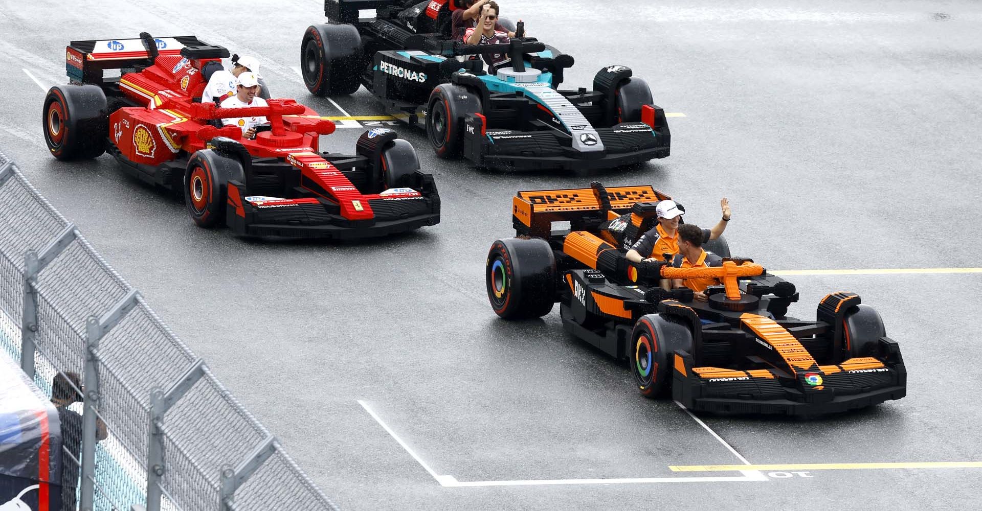 MIAMI, FLORIDA - MAY 04: Charles Leclerc of Monaco and Scuderia Ferrari, Lewis Hamilton of Great Britain and Scuderia Ferrari, George Russell of Great Britain and Mercedes AMG Petronas F1 Team, Andrea Kimi Antonelli of Italy and Mercedes AMG Petronas F1 Team, Lando Norris of Great Britain and McLaren, and Oscar Piastri of Australia and McLaren race LEGO cars on the drivers parade during the F1 Grand Prix of Miami at Miami International Autodrome on May 04, 2025 in Miami, Florida. (Photo by Glenn Dunbar/Getty Images for LEGO Group)